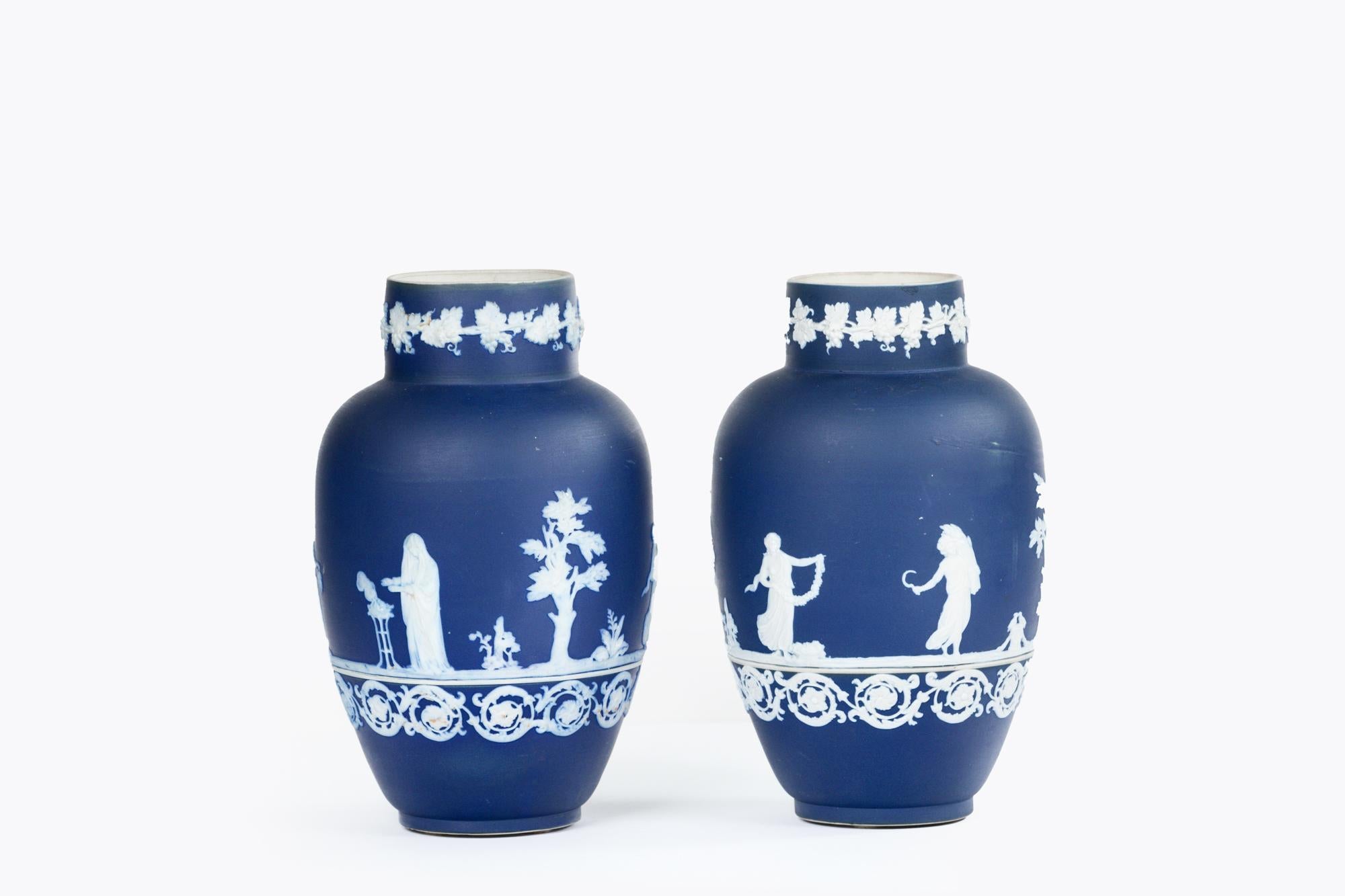 Coppia di vasi Adams Jasperware della fine del XIX secolo con delicate scene applicate raffiguranti figure neoclassiche che rappresentano le quattro stagioni, ornate da fogliame e bordi a volute. Timbro alla base.