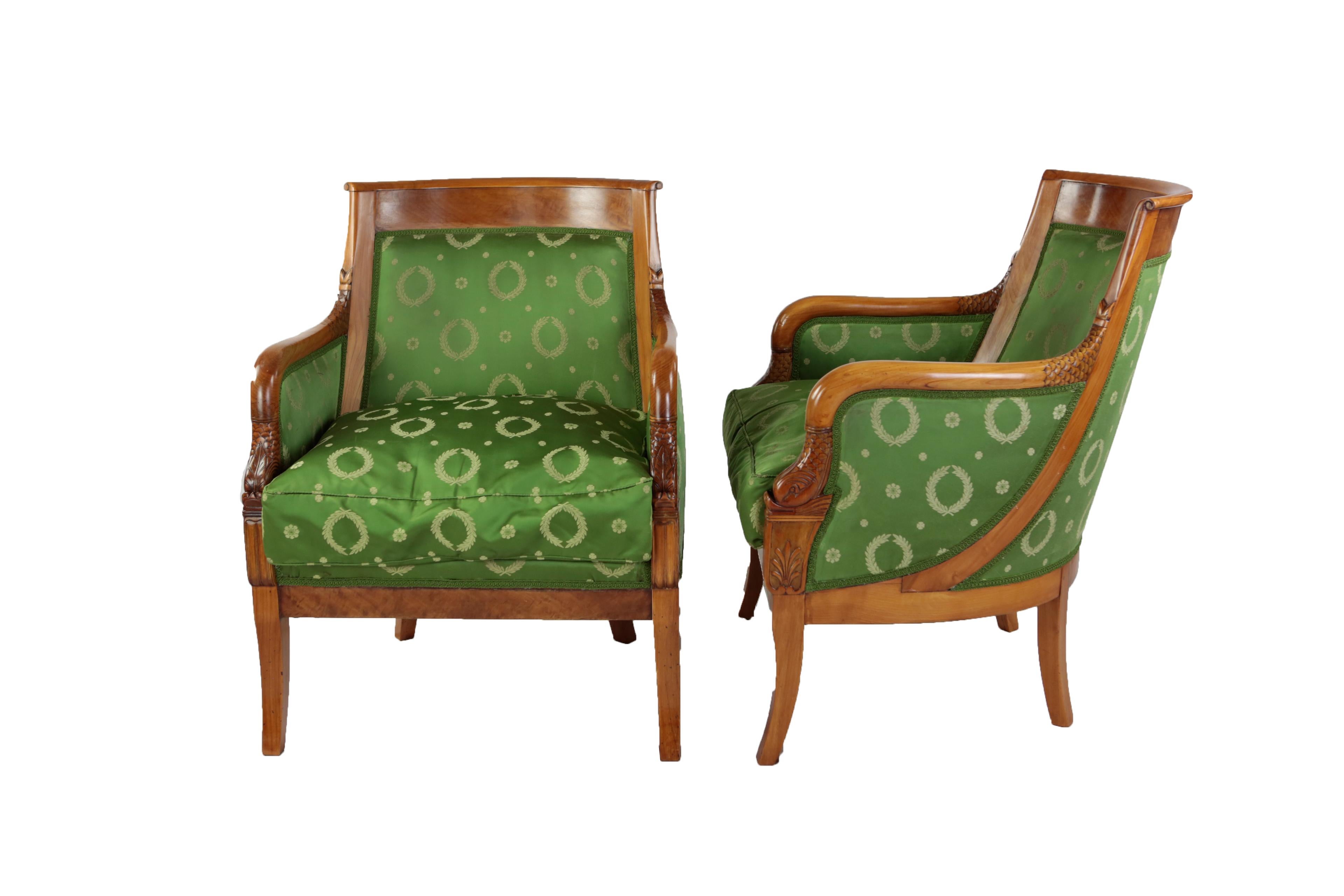 Pair of comfortable armchairs in Empire style, France, late 19th century, cherrywood and maple solid and veneered, green silk cover, loose seat cushion, restored condition, shellac polish.
Armrests with carved dolphin motif.

Armrest with dolphin