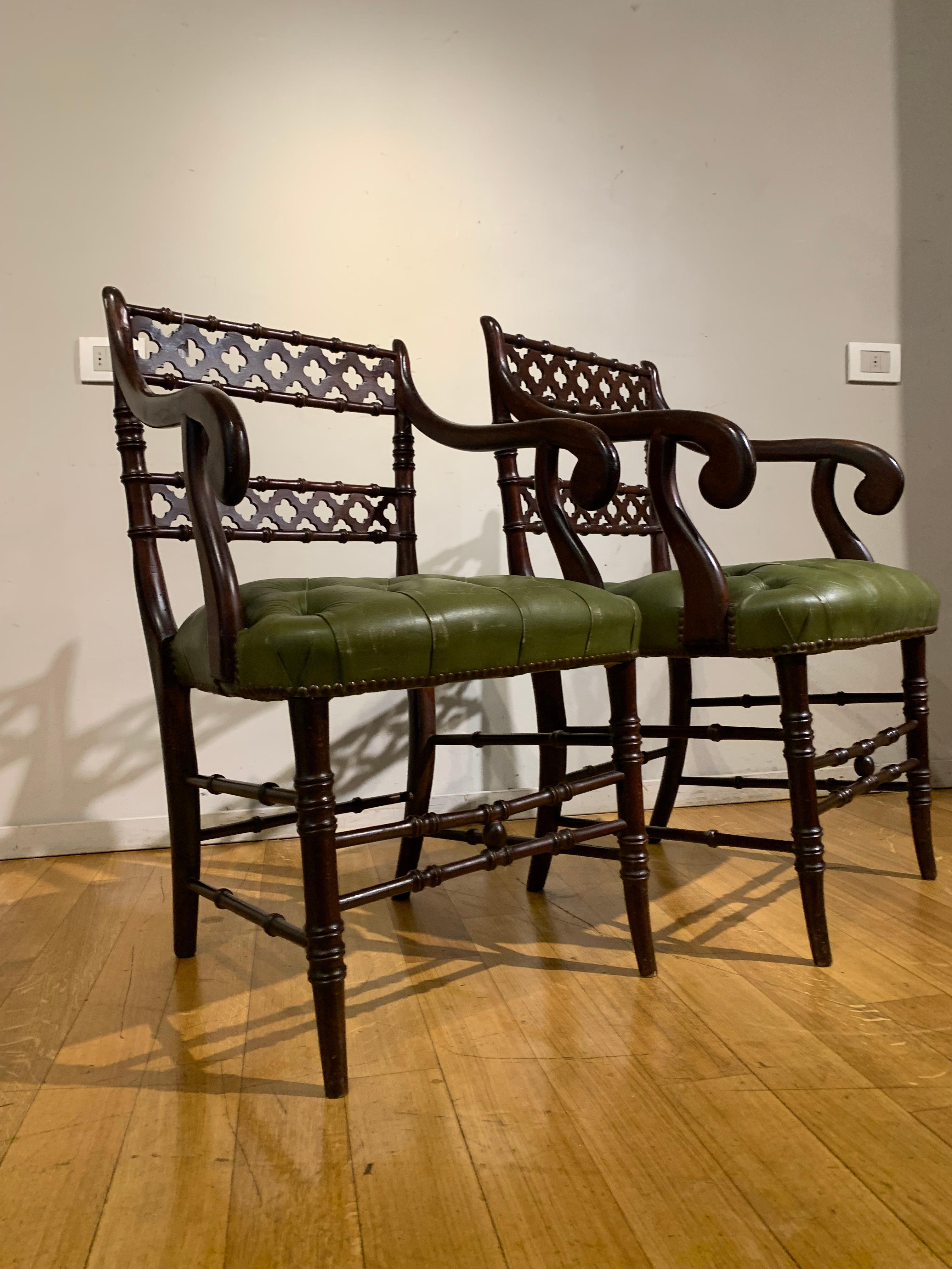 Beautiful pair of carved mahogany red bamboo-type armchairs with carvings on the perforated backs.
Particular seats upholstered in green leather capitonnè in Chester style.
English manufacture from the second half of the 19th century.