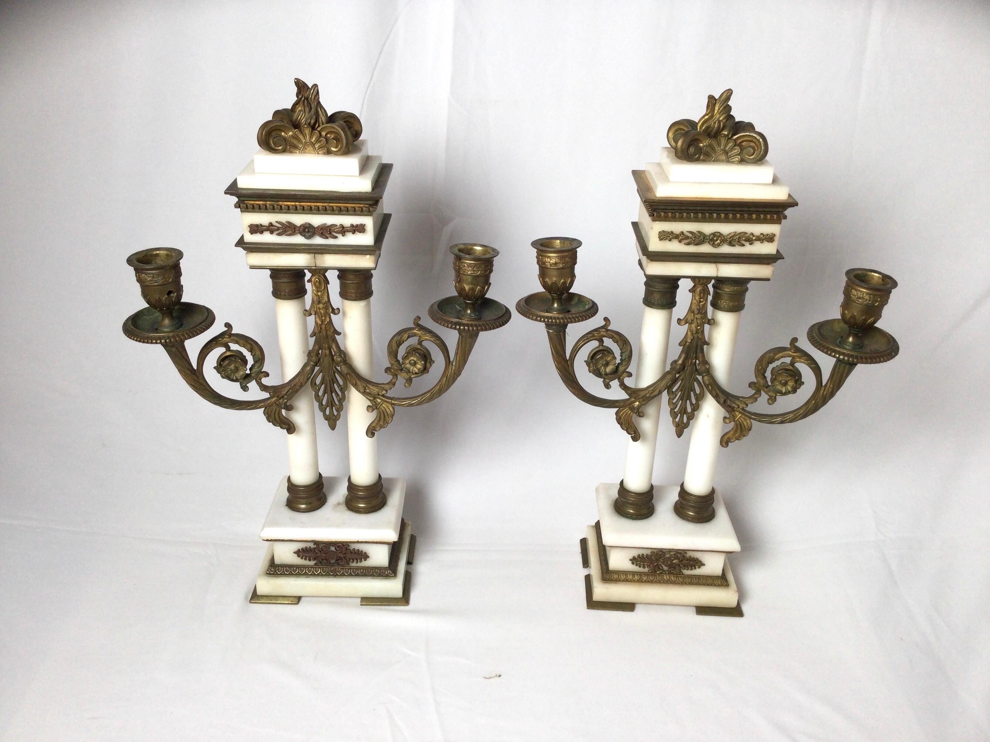 Late 19th century pair of French bronze and marble candelabras, neoclassic form with white marble columns and aged gilt bronze mounts. The fronts with scrolled arms to accommodate two candles.
Dimensions: 18