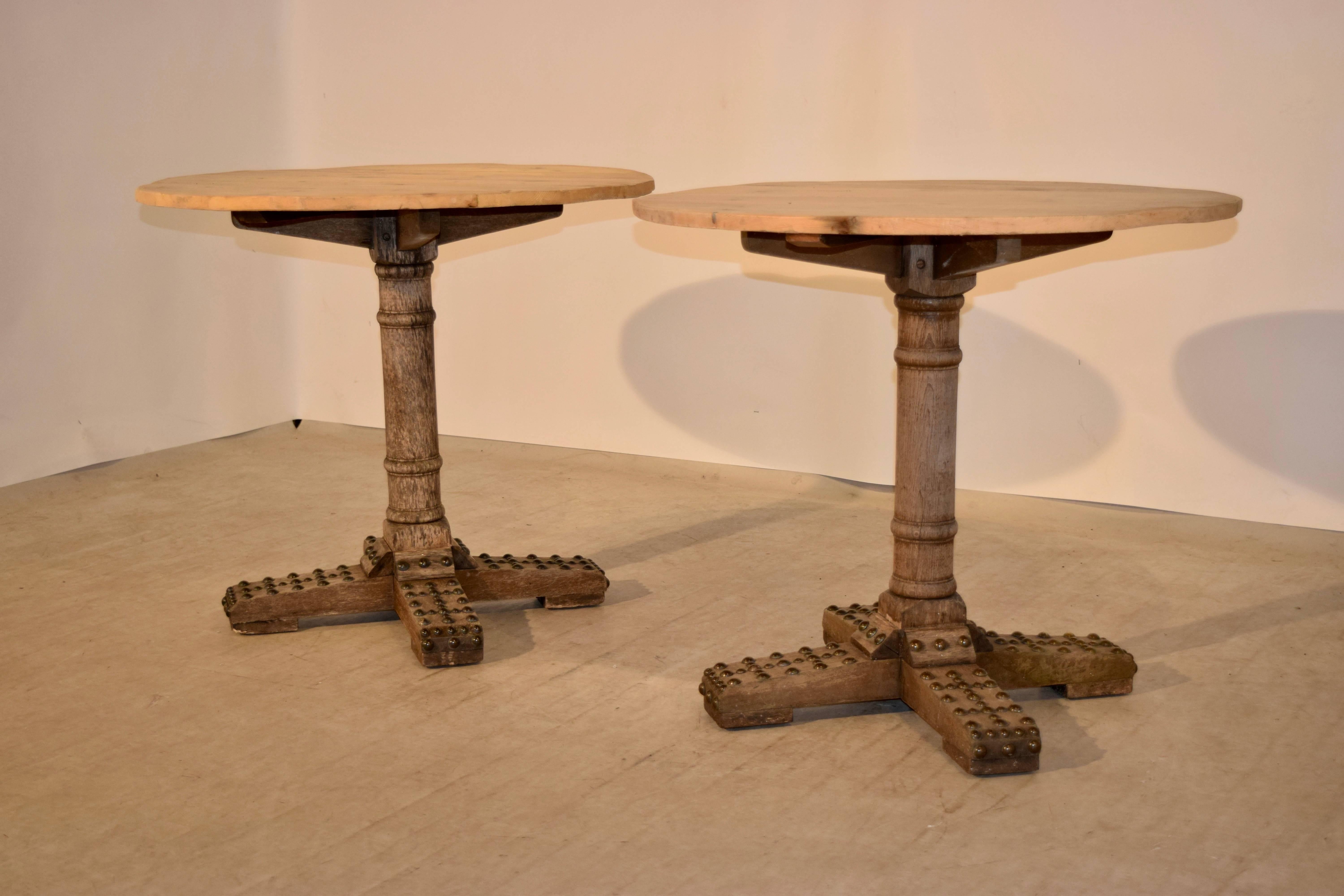 Late 19th century pair of pine tables from France with plank tops following down to hand-turned bases, which are supported on X-shaped bases, decorated with brass studs.