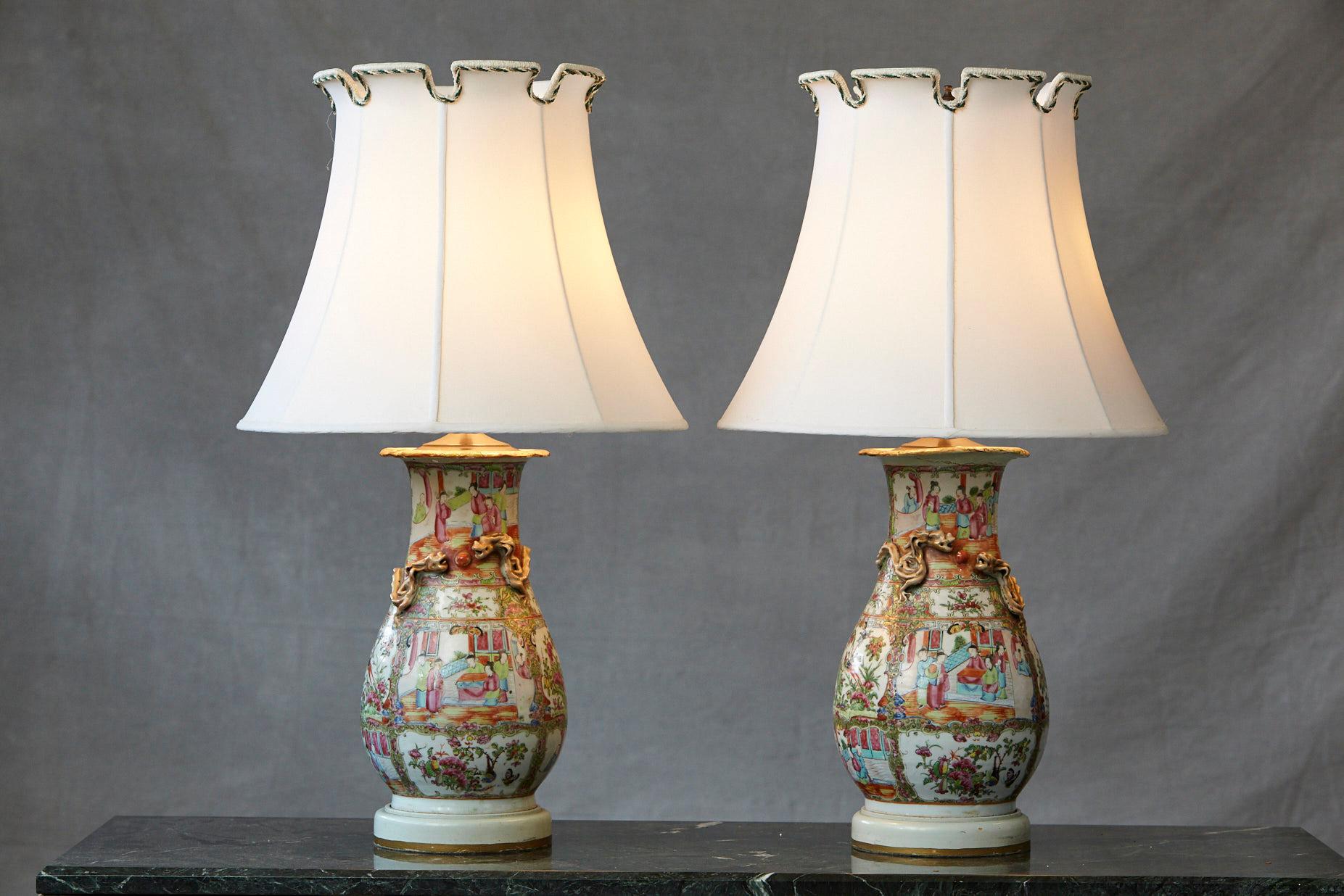 Impressive pair of late 19th century hand painted Chinese porcelain vase style table lamps, depicting in great detail traditional Chinese scenes from people's daily life, birds, nature and elaborated flower arrangements. Each vase has two porcelain