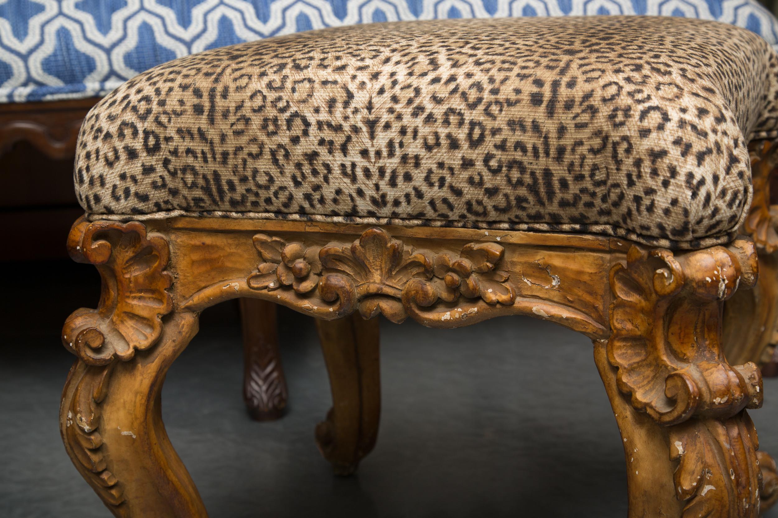 This is a pair of ornately carved Italian beechwood stools with a faux leopard fabric seat, late 19th century.