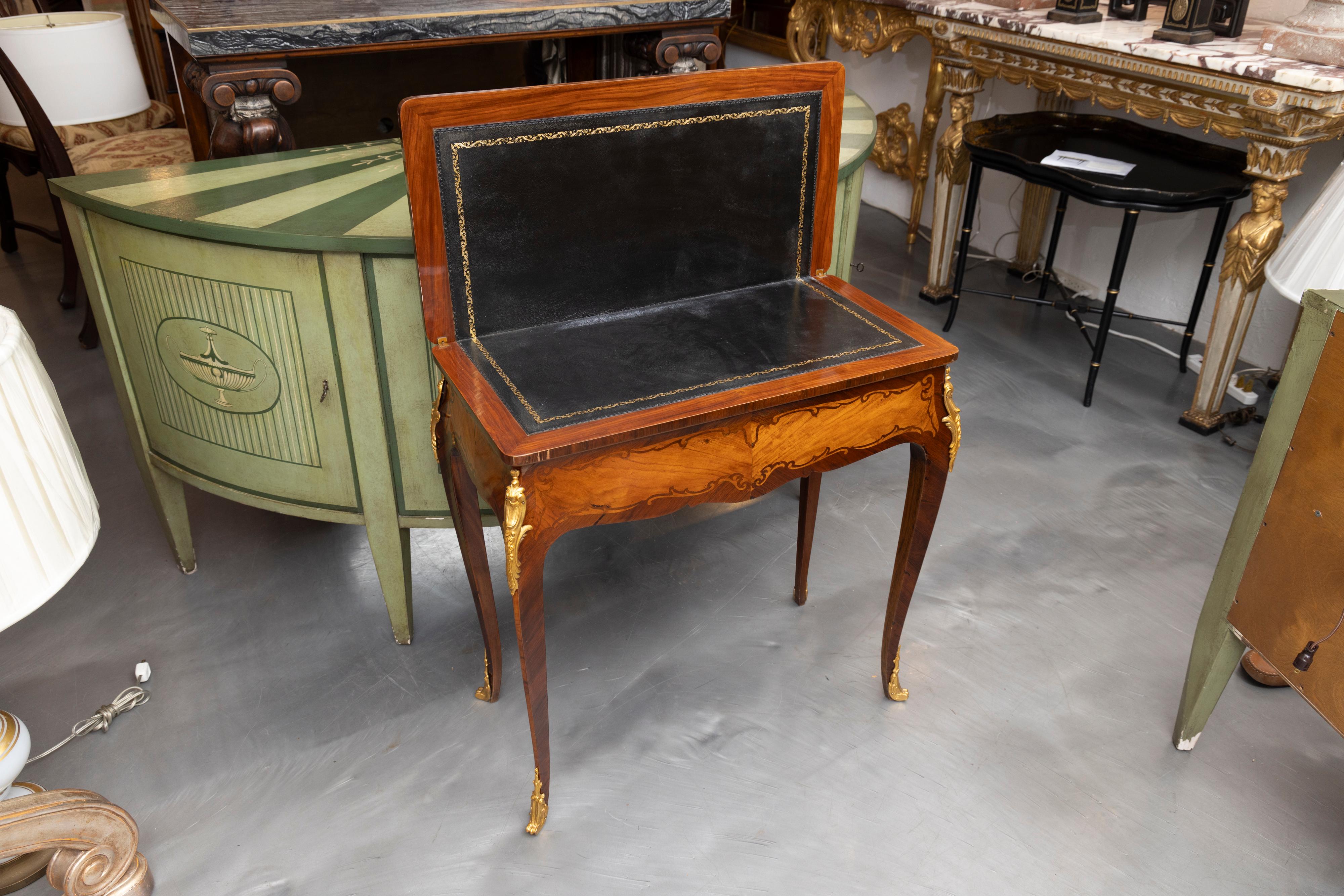 This is a classic pair of late 19th century mahogany and king wood Louis XV style inlaid game tables with the top opening to reveal a leather-inset, supported by graceful slender cabriole legs with ormolu mounts. Pair available, priced individually.