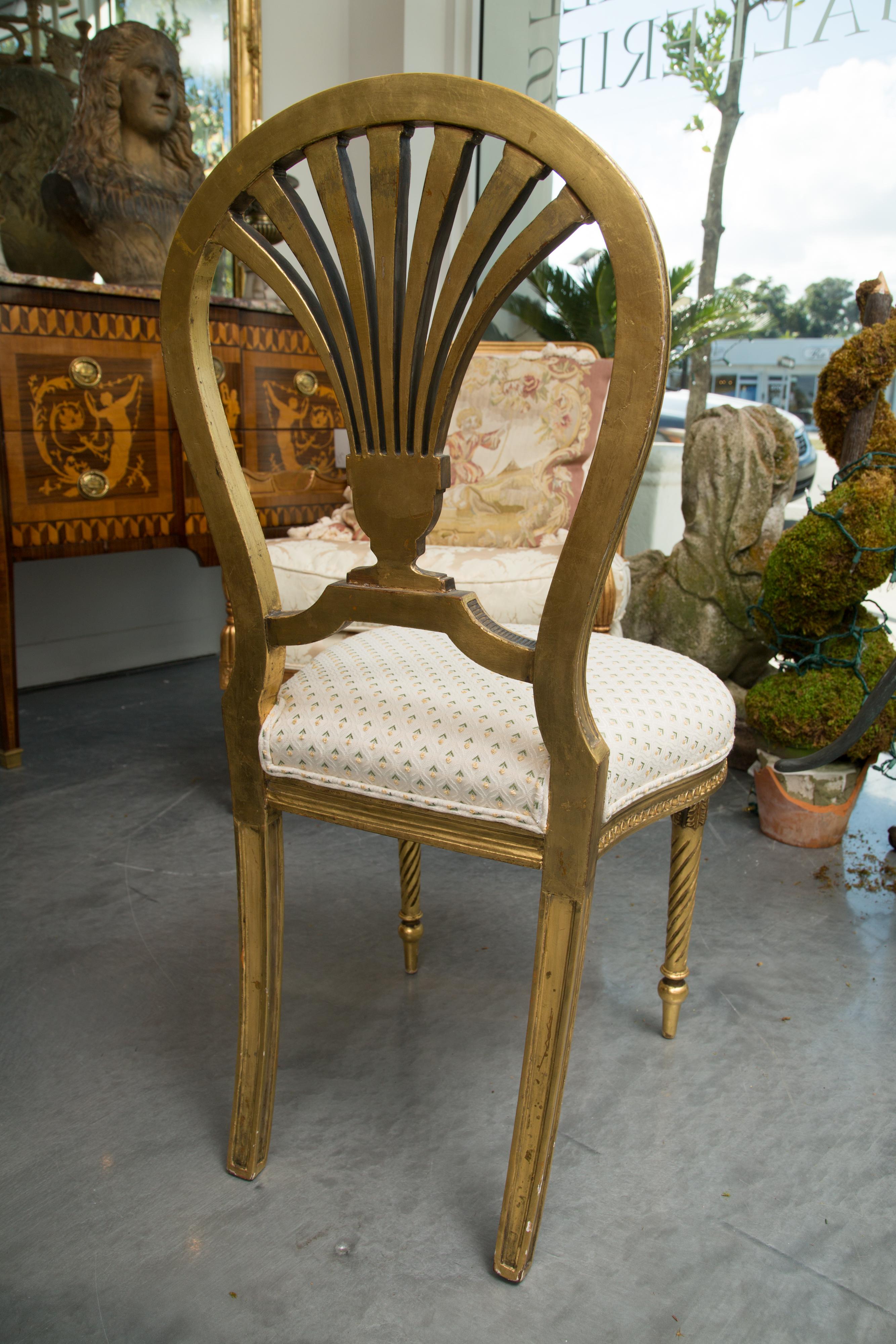This is a sophisticated pair of Louis XV style side chairs. The oval back has an exterior beaded molding and interior rope molding surrounding a fan-shaped ornamental back splat above an upholstered seat. The chairs are raised on front round tapered