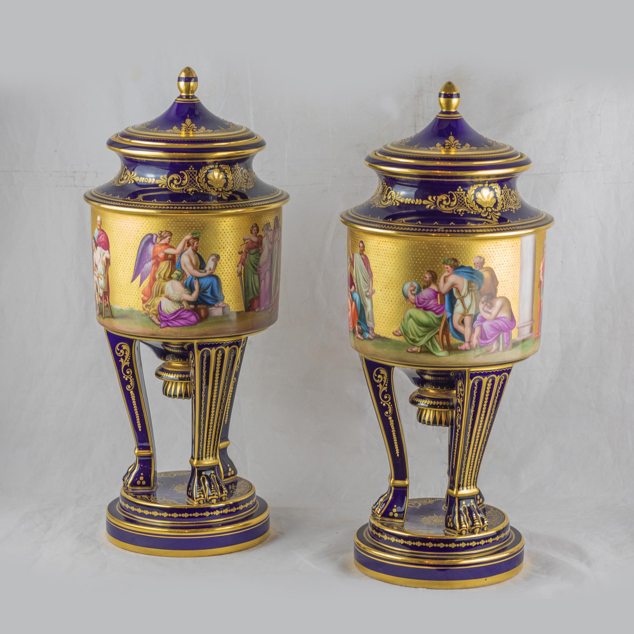 A fine pair of Vienna style porcelain gilt and cobalt-blue ground vases with covers, late 19th century. Each painted with a continuous mythological view, raised on three paw feet above a stepped circular base. The blue beehive marks, gilt mark,