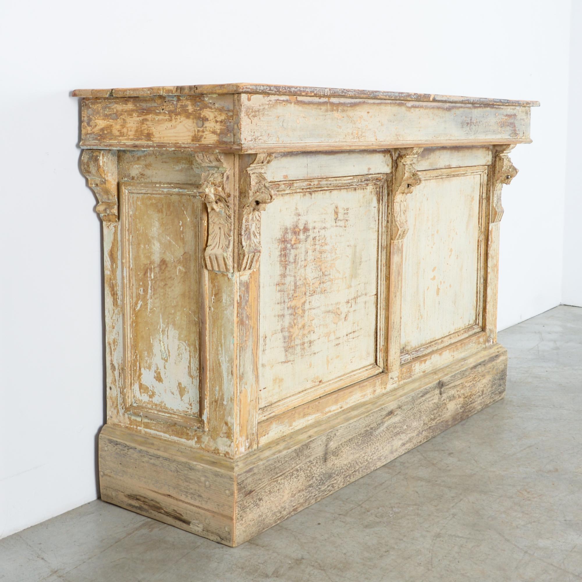 From Paris, circa 1880, this neoclassical store counter reflects the era of eclectic French interior design of the highest level. A simple bar counter is elevated with lion’s head corbel motif, and thick proportions, cloaked in a striking patina.