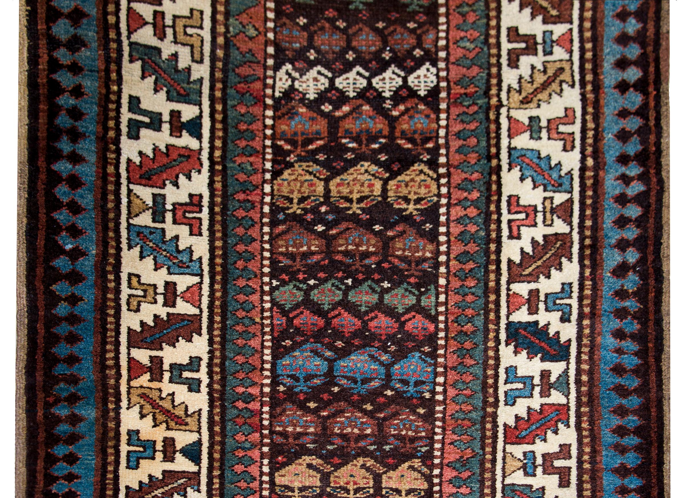 Superbe chemin de table Perse Kuba de la fin du 19e siècle, avec le plus beau motif cachemire tissé dans une myriade de couleurs dont l'indigo, le cramoisi, le jaune, le vert et le brun de la laine, entouré d'une bordure de multiples rayures