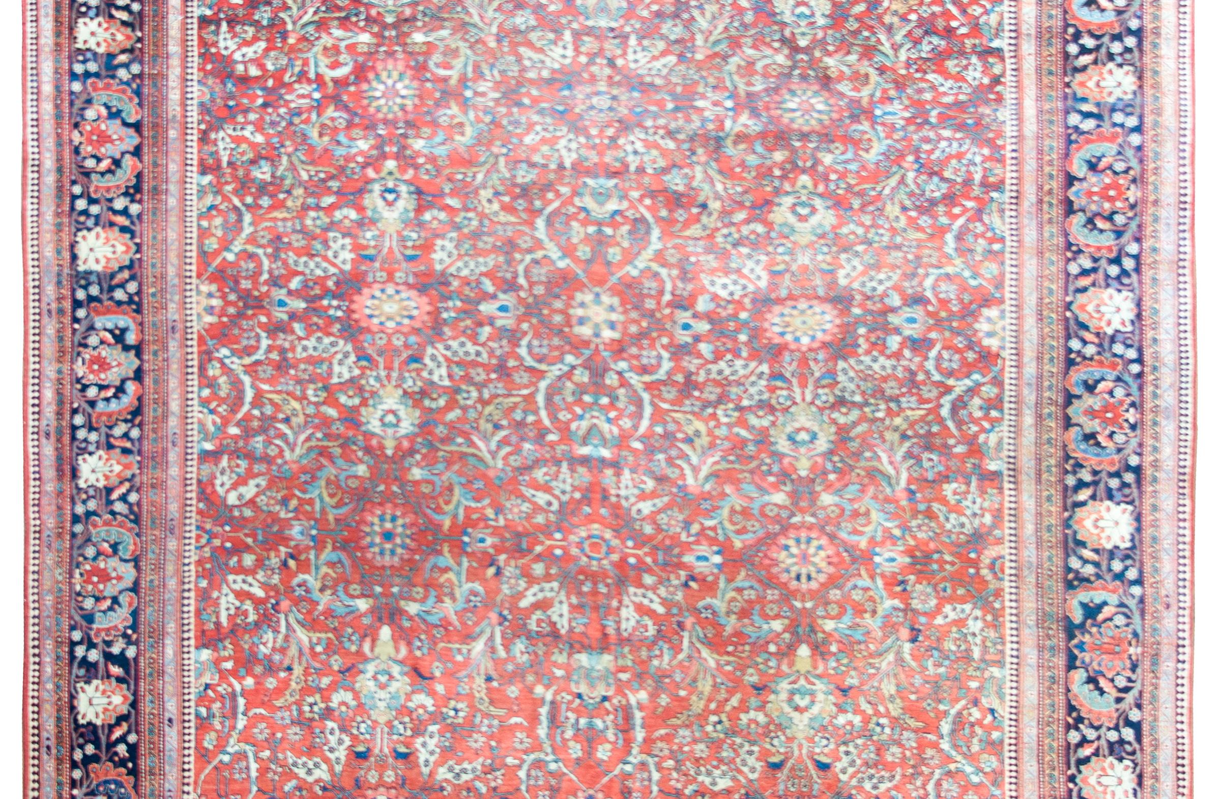 Uno splendido tappeto persiano Sarouk Farahan della fine del XIX secolo, con un campo a traliccio e a tralcio a specchio con fiori e foglie di grandi dimensioni, circondato da un incredibile bordo con altri fiori di grandi dimensioni ripetuti