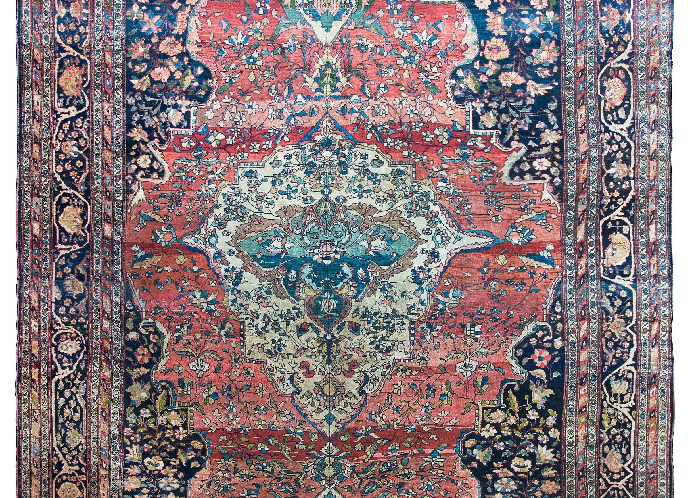 Incroyable tapis persan Sarouk Farahan de la fin du XIXe siècle, avec un grand médaillon floral central asymétrique sur fond abrash indigo et une myriade de fleurs stylisées et de vignes en volutes sur fond abrash cramoisi, entouré d'une bordure