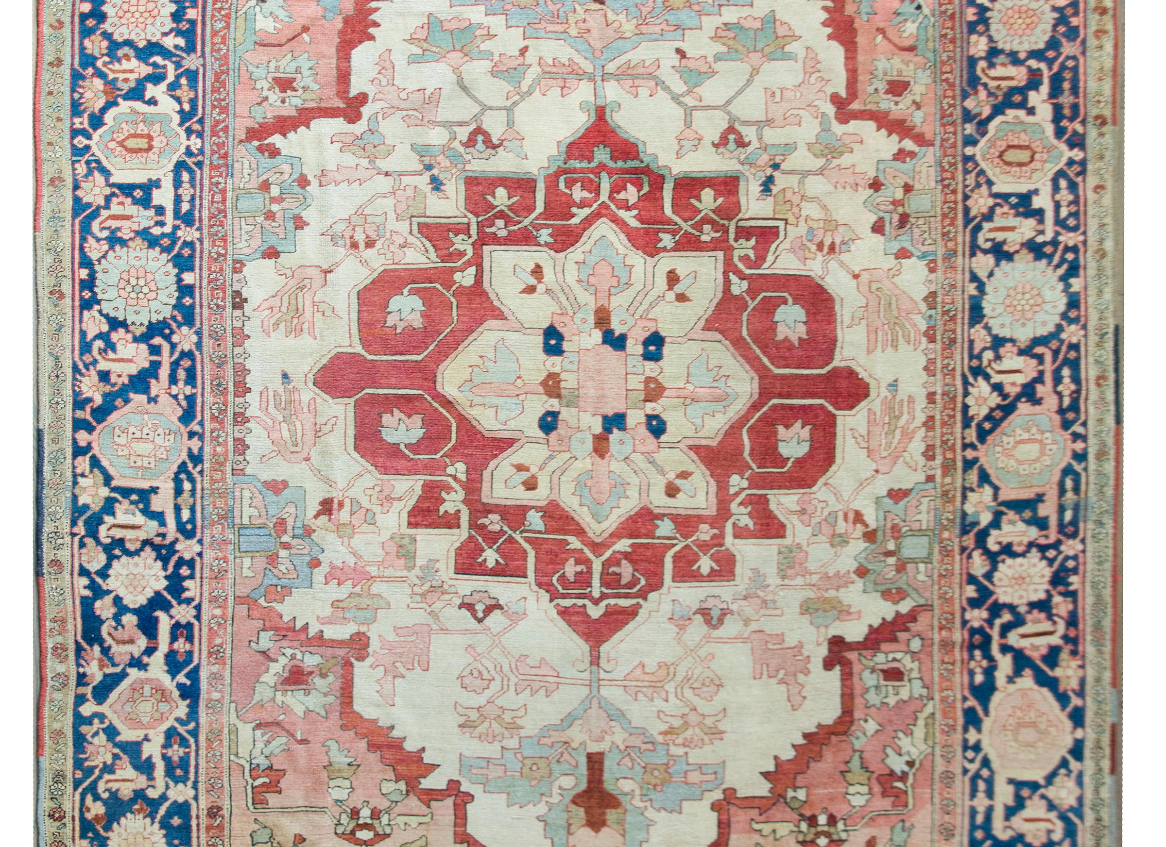 A stunning late 19th century Persian Serapir rug with an incredible large-scale crimson floral medallion set against a field of leaves, flowers, and scrolling vines, and surrounded by a wide large-scale floral and scrolling vine patterned border