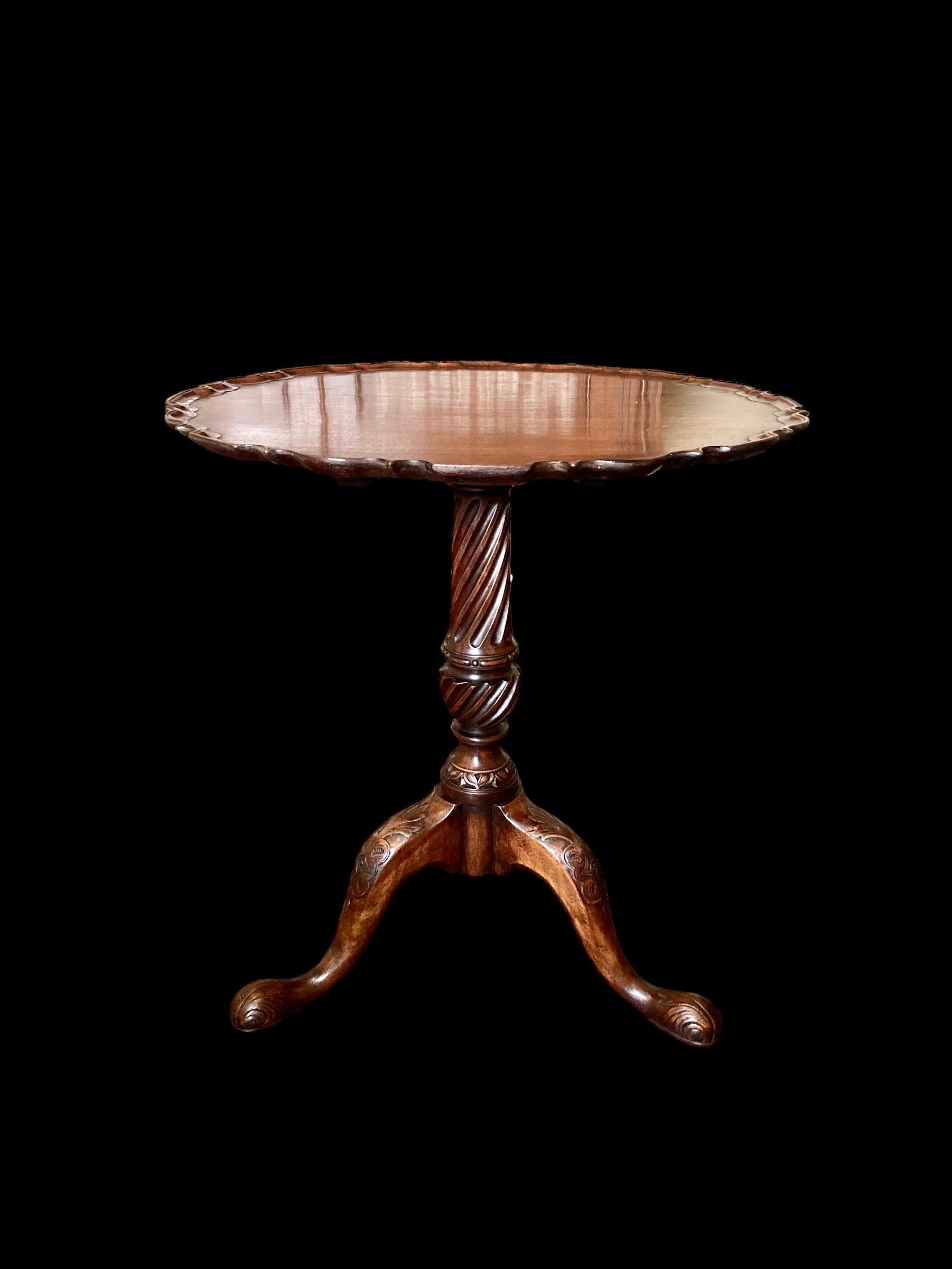 A delightful late 19th Century mahogany pie crust, occasional or tea table, with tilt top. The pedestal base carved with a substantial and handsome fluted column resting on finely carved downswept legs with carved knees terminating on three carved