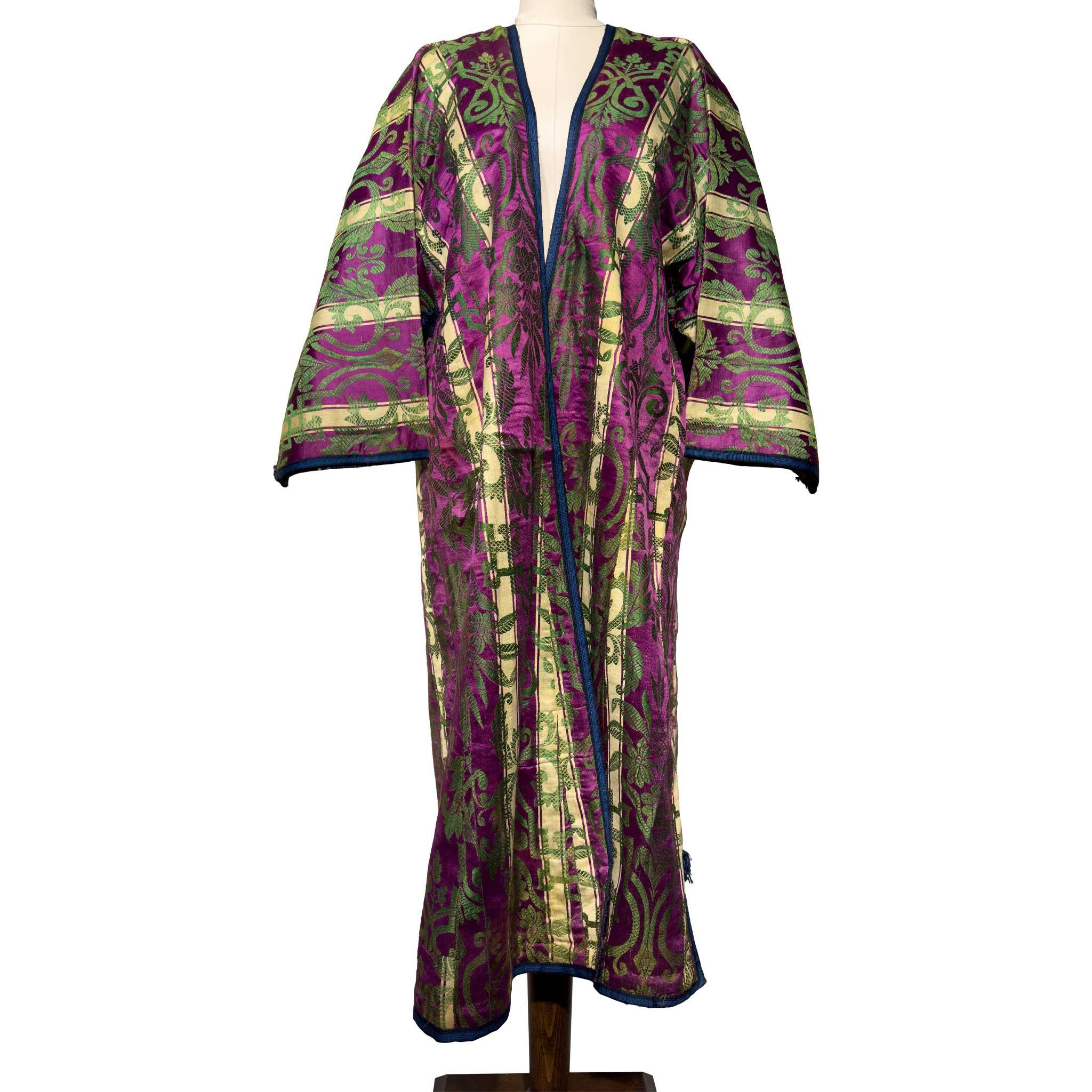 Dieser gesteppte Seidenkaftan aus dem späten 19. Jahrhundert ist ein leuchtendes Beispiel für die Textilkunst Zentralasiens. Die Oberfläche des in Magenta-, Grün- und Goldtönen gewebten Stoffes weist komplizierte pflanzliche Muster auf, die durch