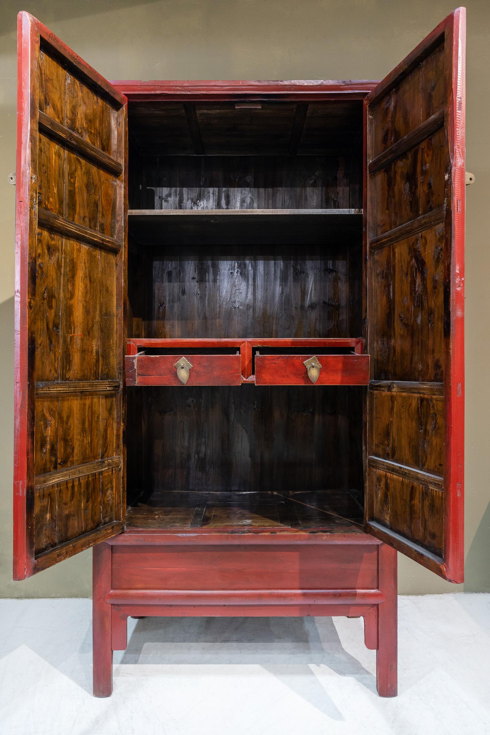 A classic Ming-style design, the round corner tapered cabinet, this piece in red lacquer was made using Cypress wood and was used in bedrooms as a wardrobe, storing clothing as well as bedding. The round brass plate on the doors are original, it has