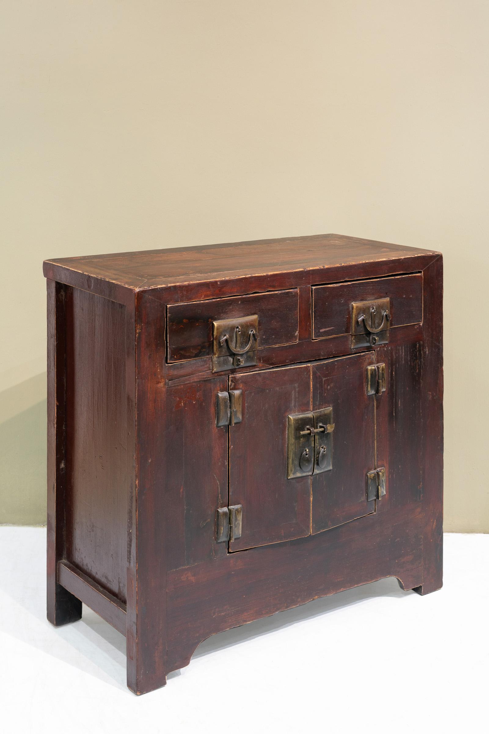 A medium sized late 19th cabinet from Shanxi province, China, that is made of Elm and Pine woods. The bulging brass handles are original, and this handle design is a distinct trait of this type of cabinet. The long metal piece in the middle of the