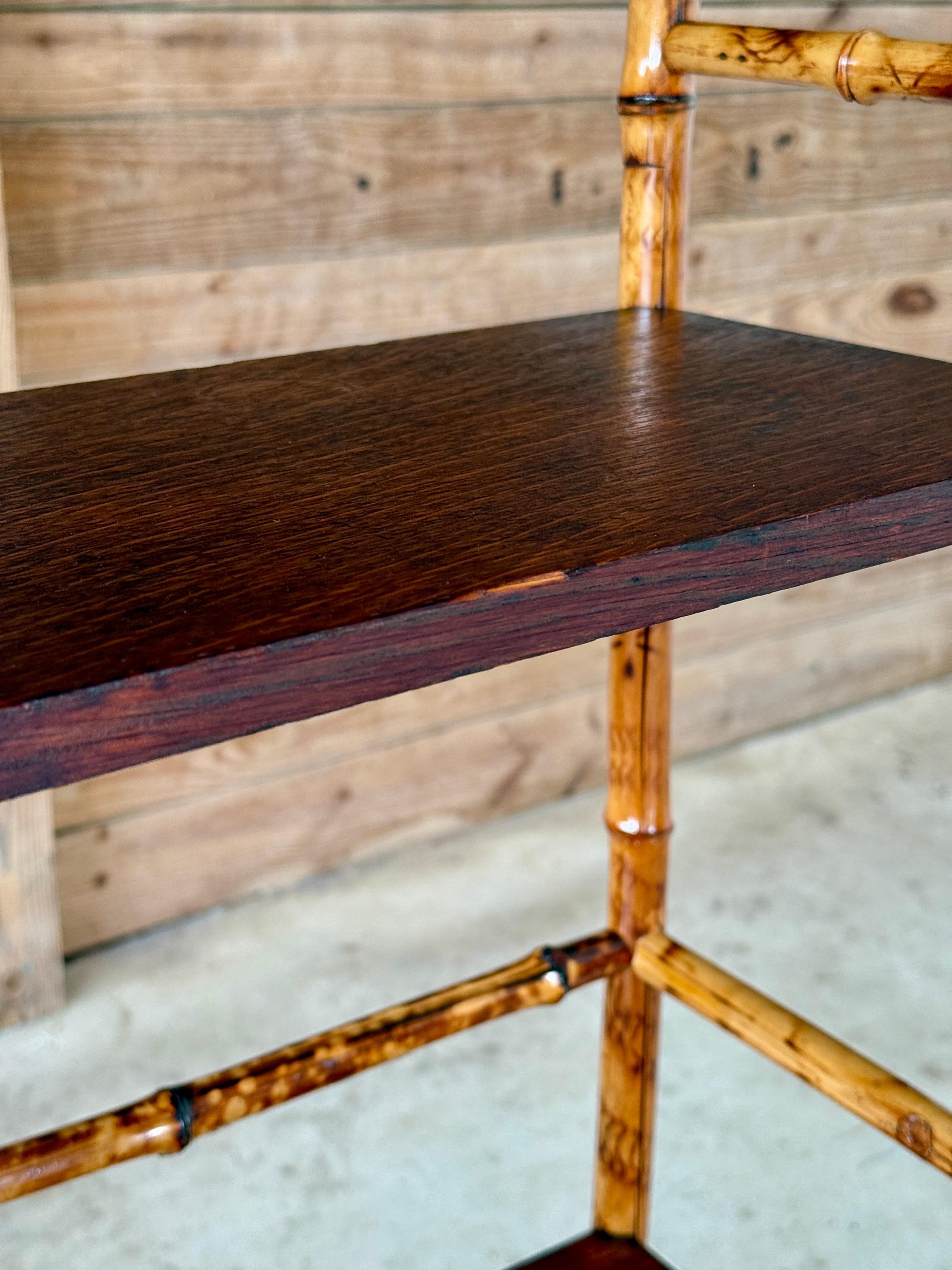 Este étagère de bambú y madera de finales del siglo XIX, un sorprendente ejemplo del diseño del Movimiento Estético Victoriano, ha sido cuidadosamente restaurado conservando su encanto original. Con detalles arquitectónicos, delicados husillos de