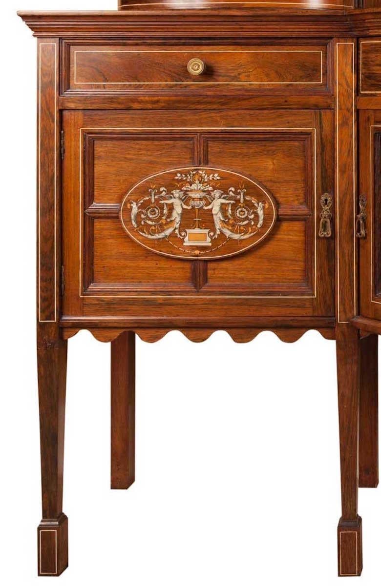 Highly decorated rosewood cabinet dresser.
The top inverted centre decorated with a carved fan shape, inlaid dragons and urns, central mirror and further inlaid foliage/urns. Bow fronted glazed cabinets to both sides with pierced galleries and