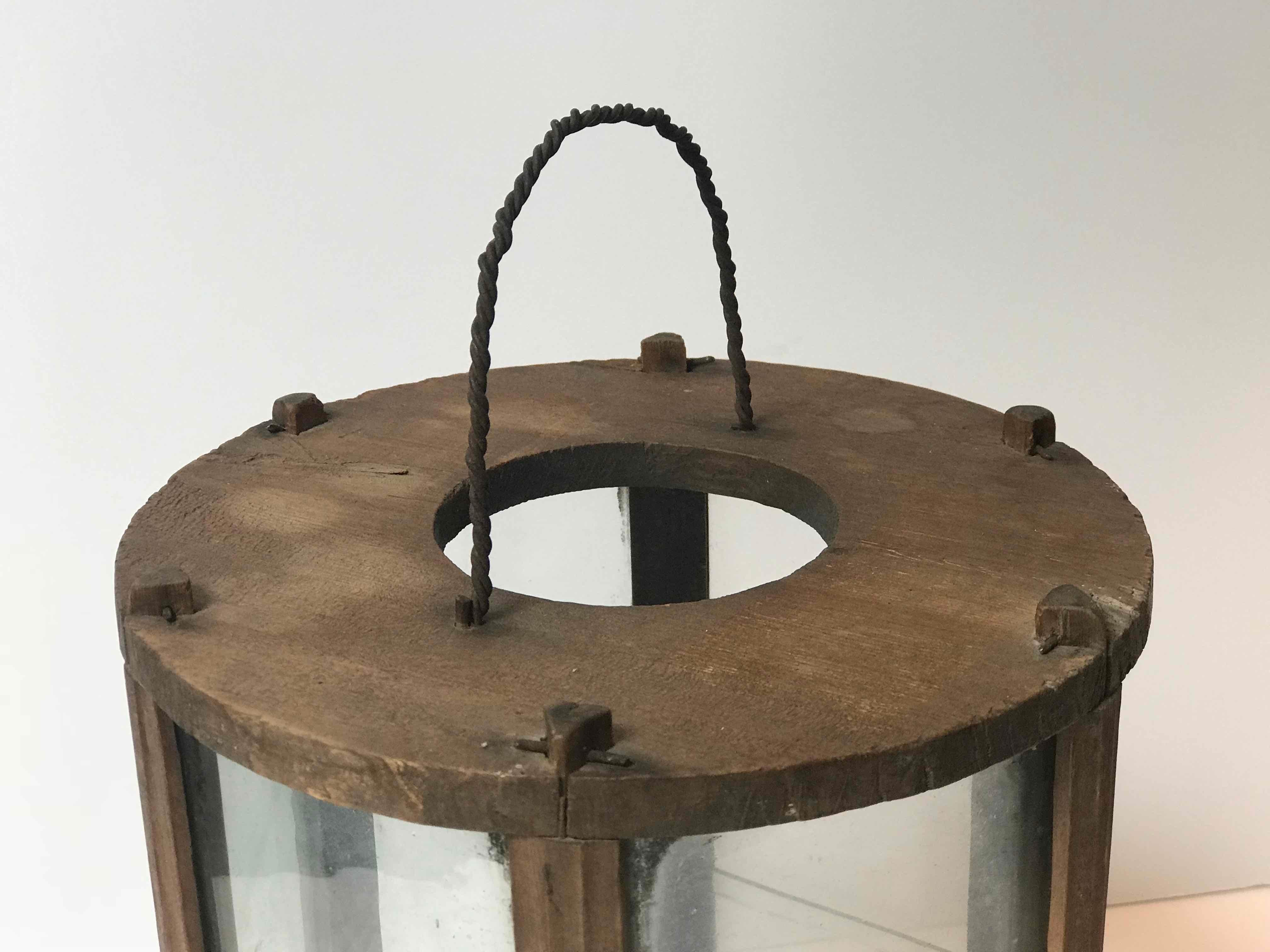 Swedish 19th-century six-sided wooden hurricane lantern or lamp with original glass and metal carrying handle. Rustic and understated, the lamp is mounted on a circular base that supports one standard-sized taper. The patina here is exquisite—the