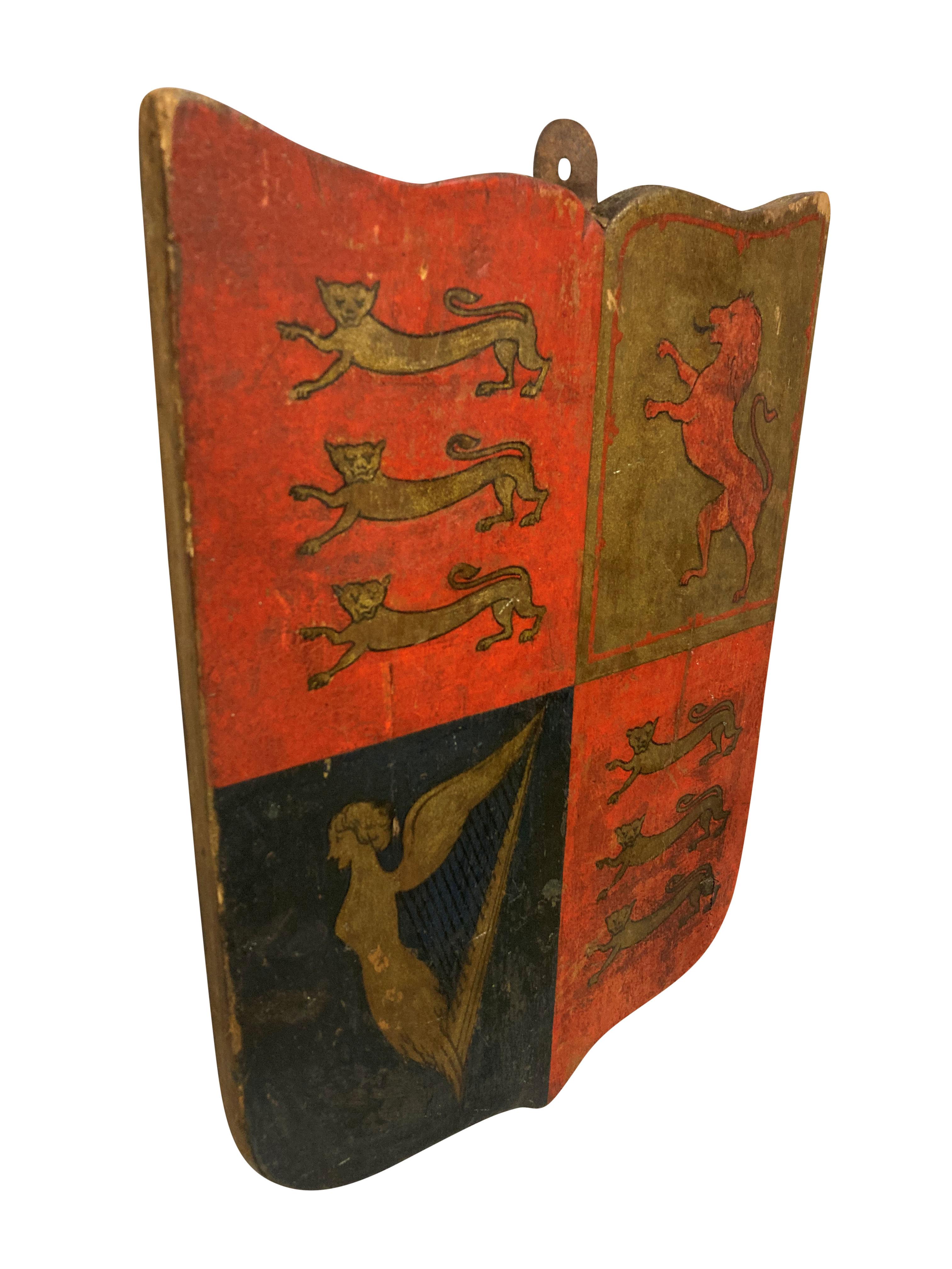A late XIX Century hand painted and gilded wooden shield bearing the Royal coat of arms of The United Kingdom.