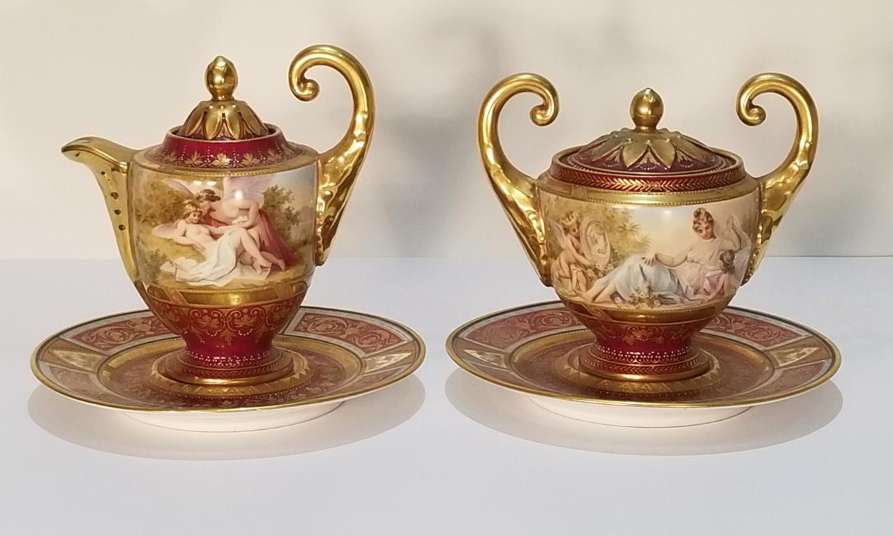 Le sucrier et le crémier Royal Vienna avec les assiettes inférieures sont marqués, signés et numérotés. Le crémier porte la marque bleue de la ruche et est signé Psyche Amor, Allemagne, 18283. La sous-plaque assortie porte la marque bleue de la