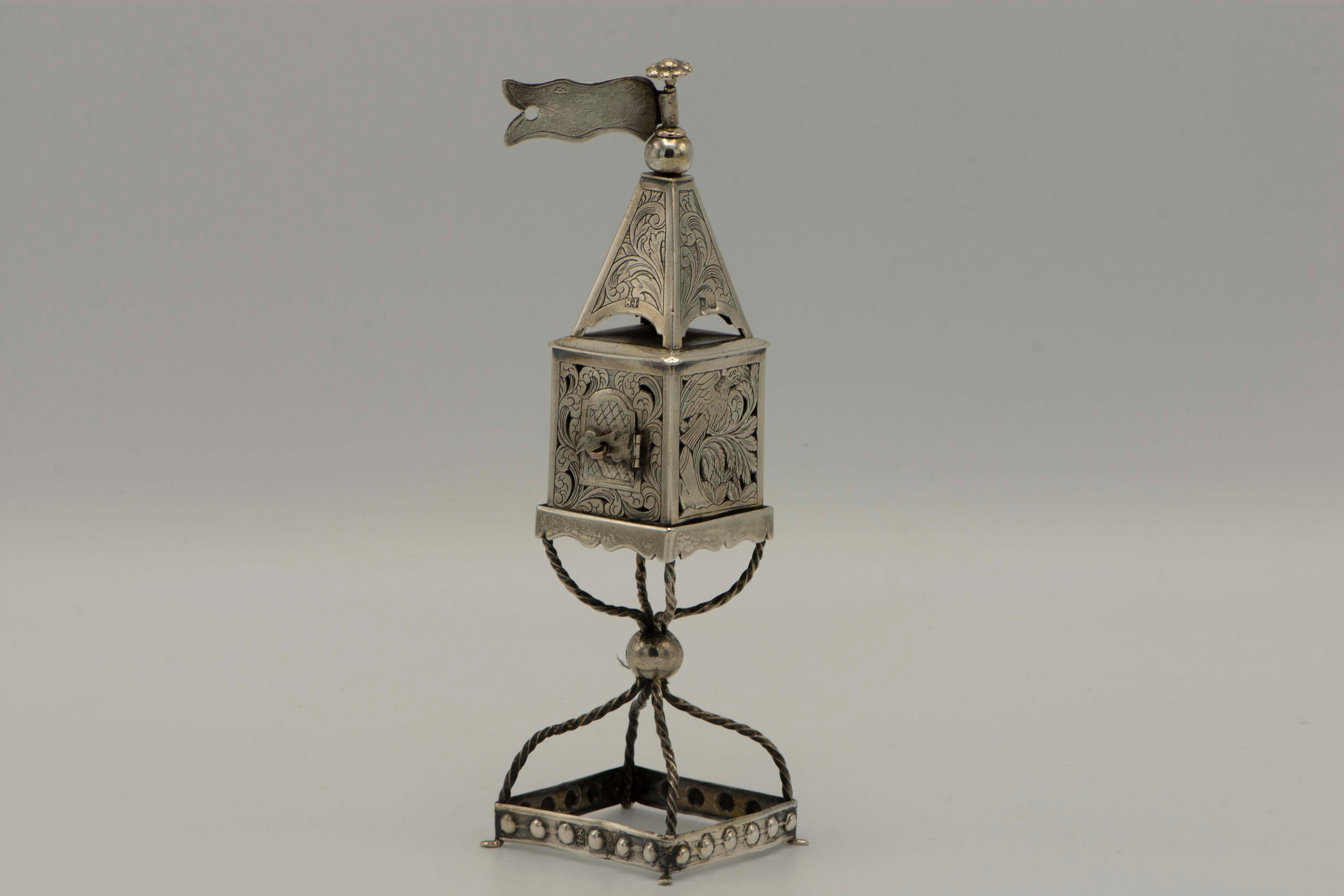 Handmade silver spice tower, Minsk, Russian Empire, 1878.
Beautifully engraved with eagle, ox, and lion amongst foliage, the spice box has a hinged door shaped as a bird, resting on wirework stem.
Marked on body door, dome, and foot.

Every item