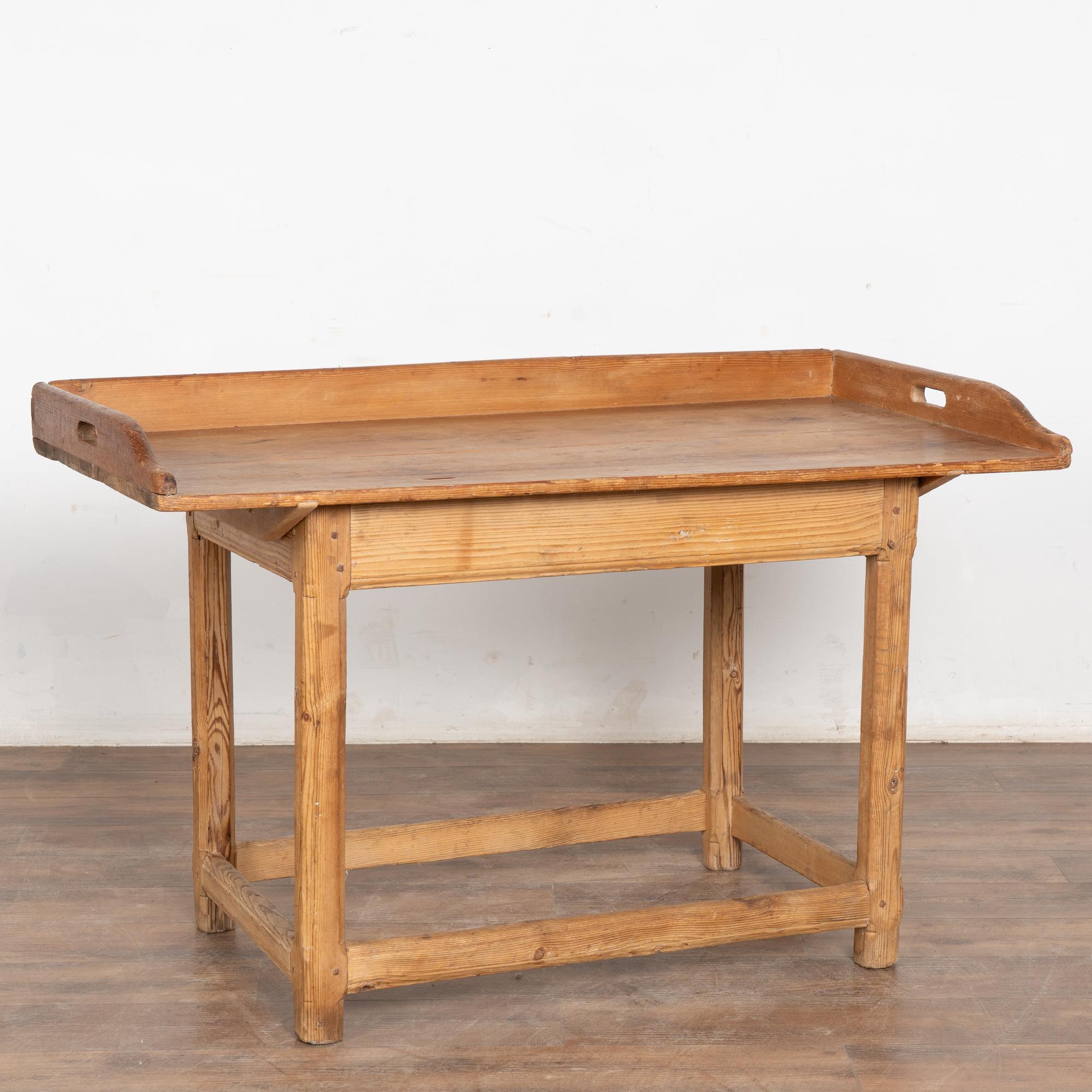 El atractivo de esta mesa rústica de pino reside en su tablero desgastado, que refleja generaciones de uso.
Originalmente sirvió como mesa de trabajo, lo que ha dado lugar a la pátina desgastada con grietas, desportilladuras, rozaduras, múltiples