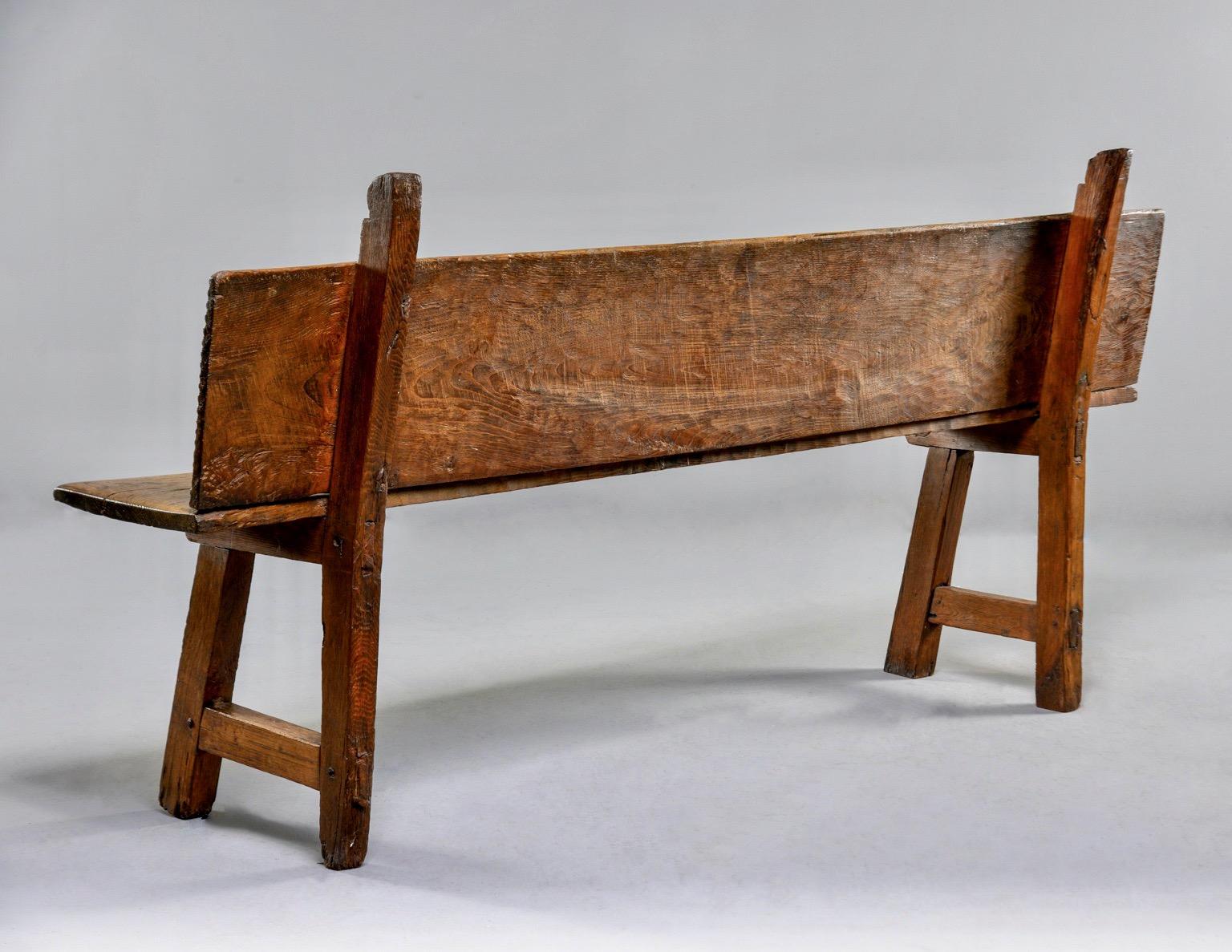Long rustic chestnut Spanish bench dates from the 1890s. Unknown maker. Measures: Seat is 20.25” high and 13” deep.