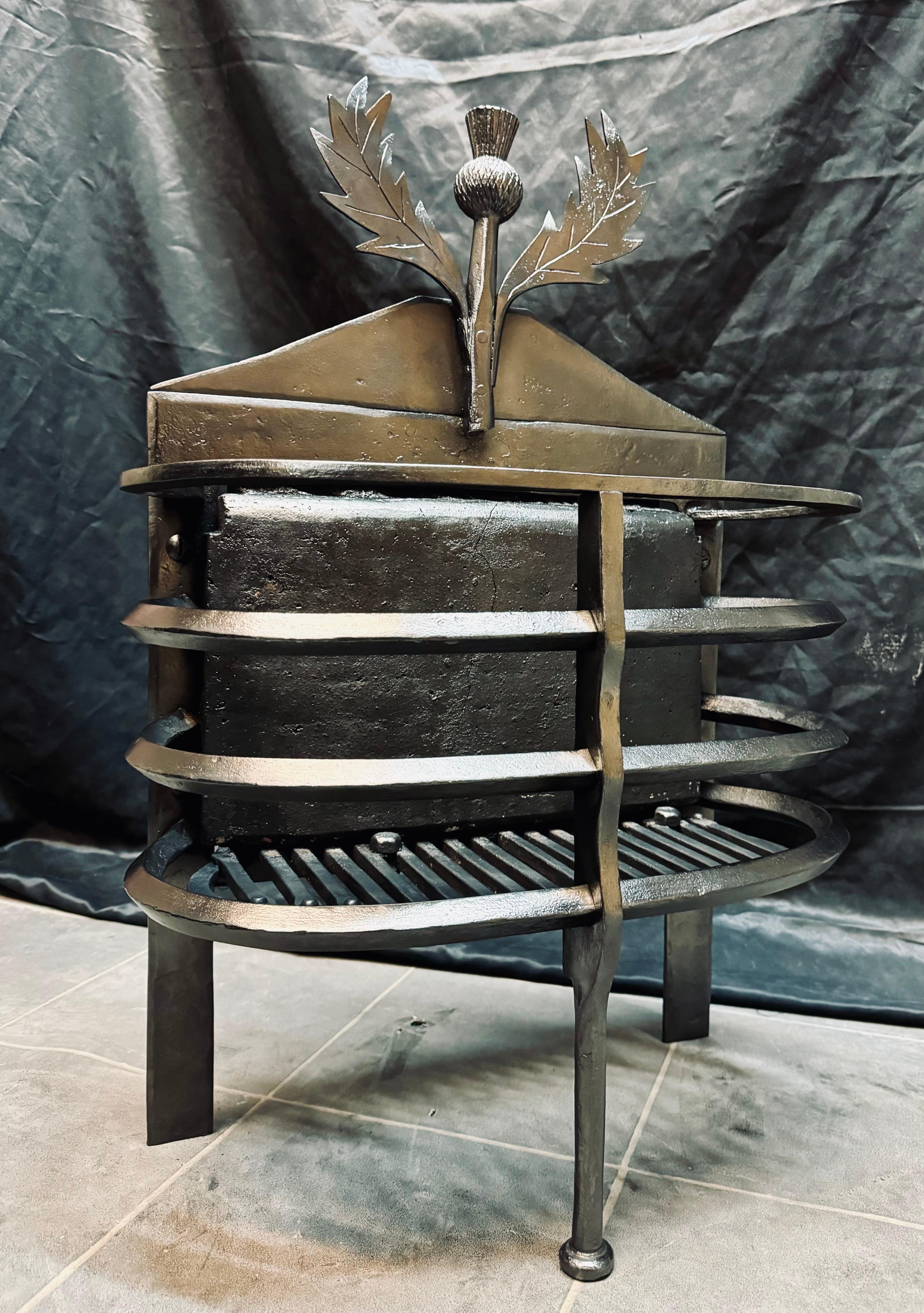 Una griglia per il fuoco in ferro battuto della fine del XIX secolo, in stile Lorimer. Un cardo singolo centralizzato con foglie che si ergono orgogliose. Lo schienale sagomato del caminetto, con una struttura a tre costole, la griglia originale
