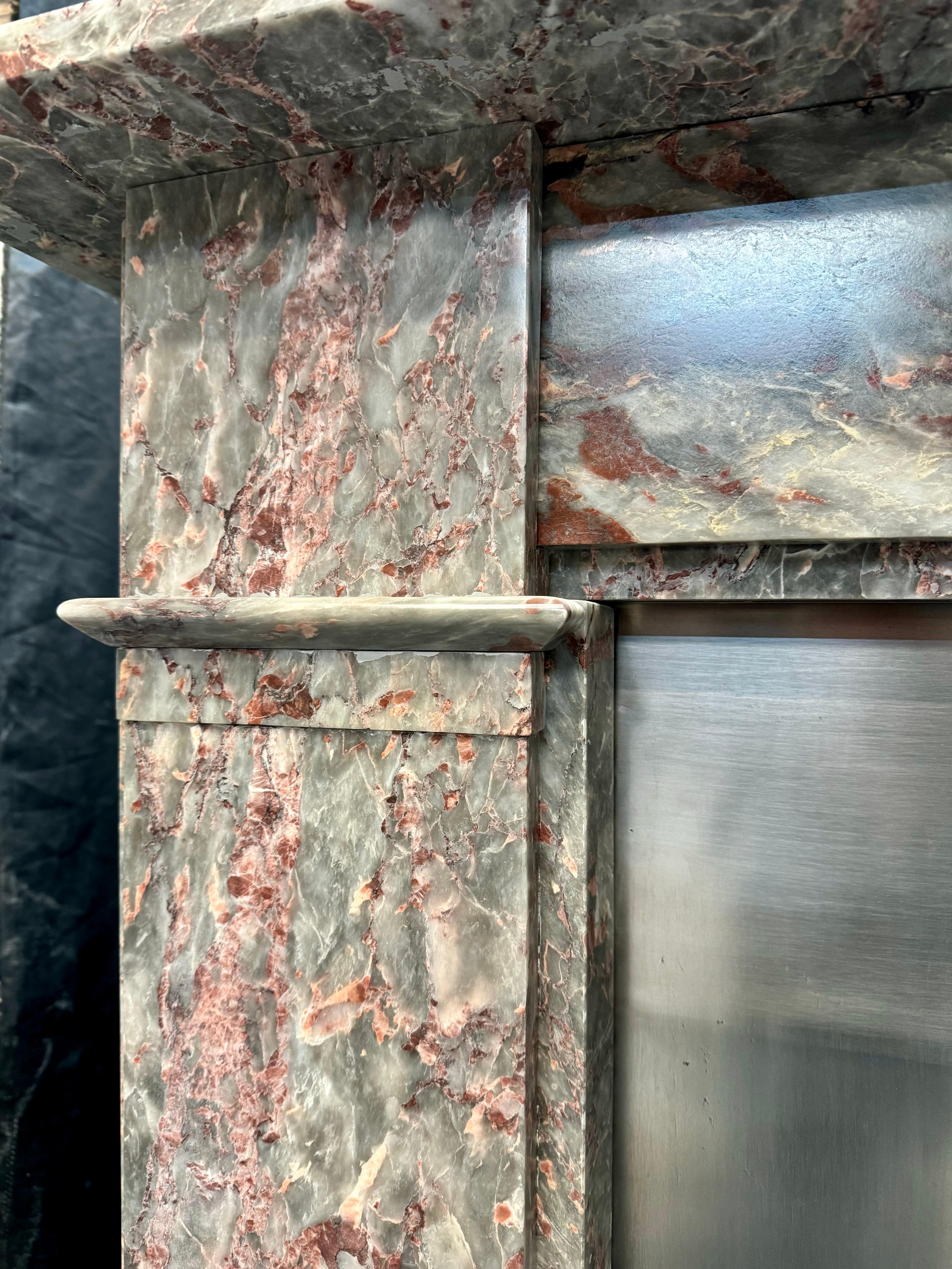 A Scottish late 19th Century Fior Di Pesco marble fireplace surround. A plain edged top shelf sits directly above a stepped frieze, flanked in turn by  substantial jambs set with intermittent splayed capping insertions, further full length stepping