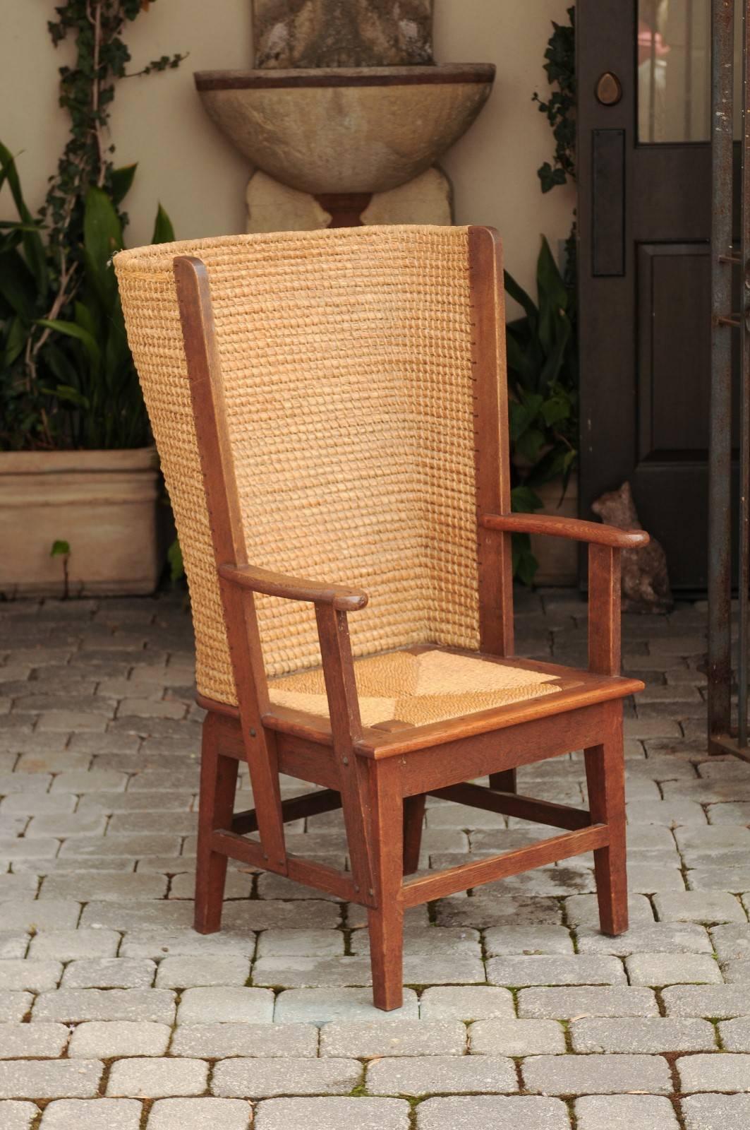 A Scottish Orkney chair with handwoven wrap around straw back, wooden arm supports without-scrolled extremities, straight legs and side stretchers from the late 19th century. This wooden and straw chair was born in the Orkney Islands near the