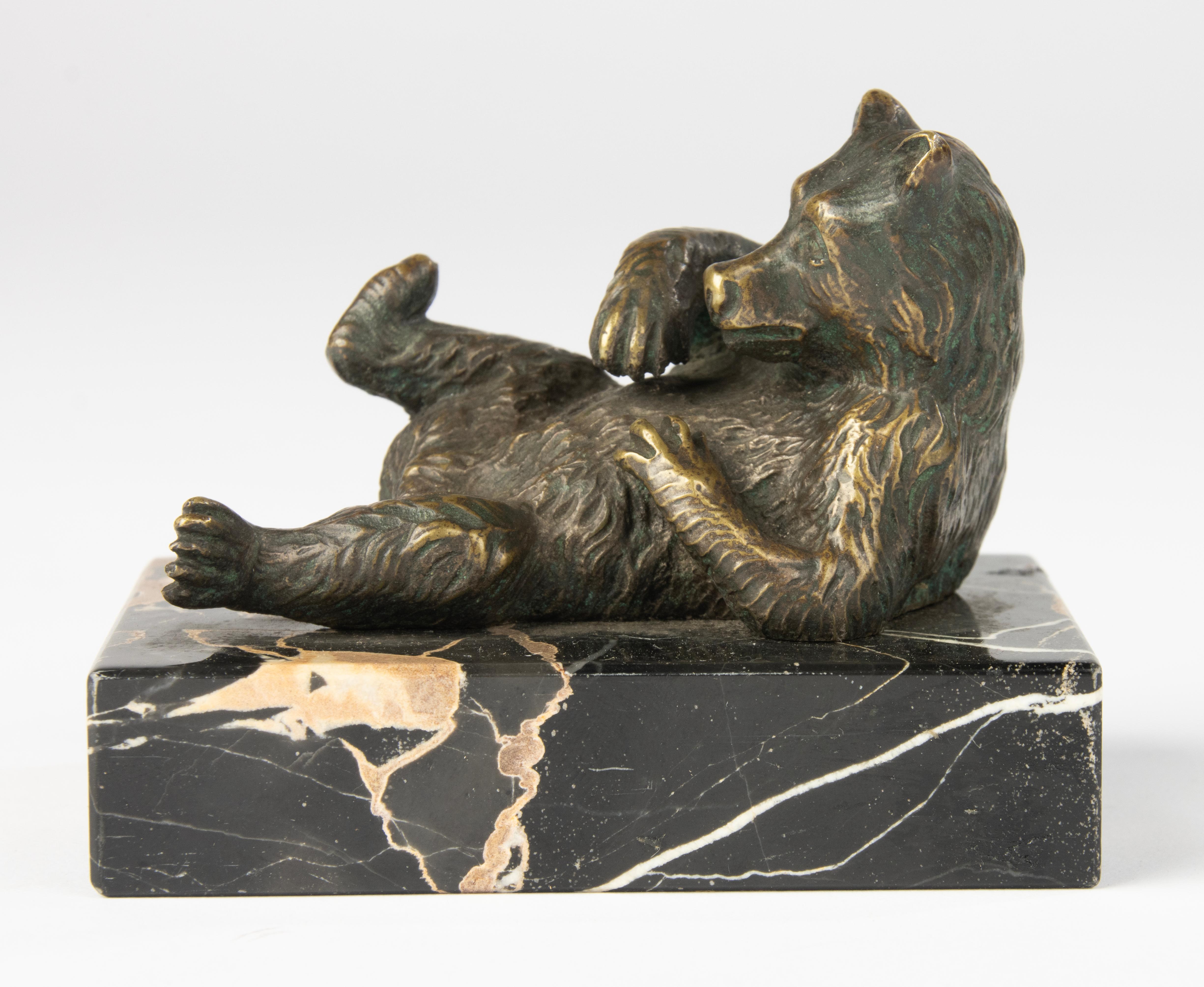 Charmante sculpture en bronze de la fin du 19e siècle représentant un ours couché, jouant sur le dos avec une patte levée. Cette ravissante pièce animalière de petite taille capture à la fois le caractère et la texture de l'ours avec de fins détails