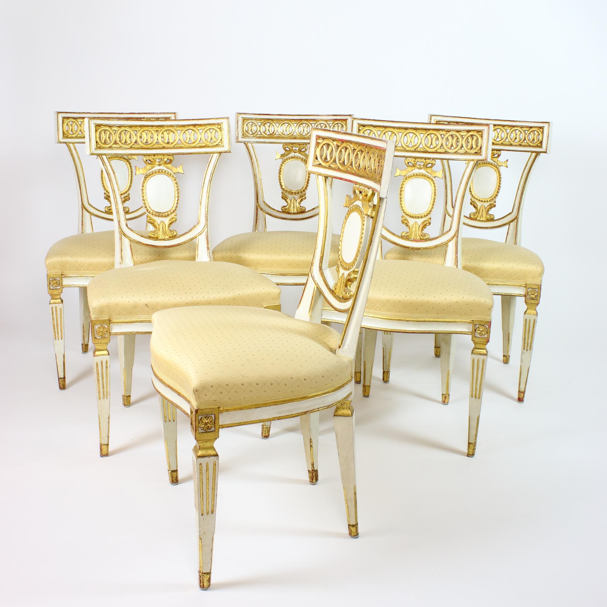 Very elegant late 19th century set of six Italian Neoclassical Klismos shaped Empire side or dining chairs: 
standing on four tapering and partially fluted legs topped by paterae cartouches a semi-eliptical seat with slightly curved front. The back
