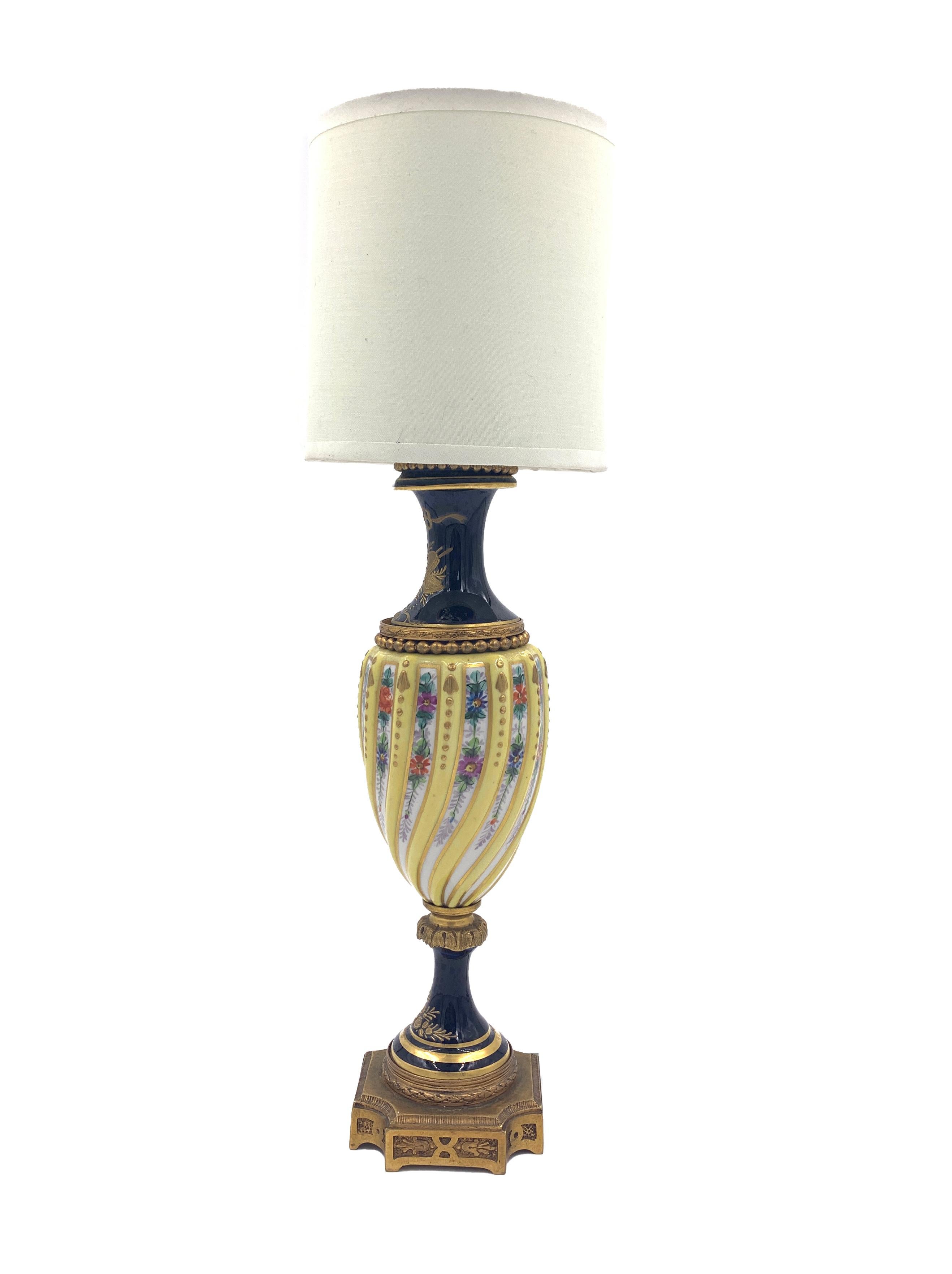 A fine yellow and blue porcelain Sevres style lamp with a twist body, hand painted with flowers and hand gilded.
 