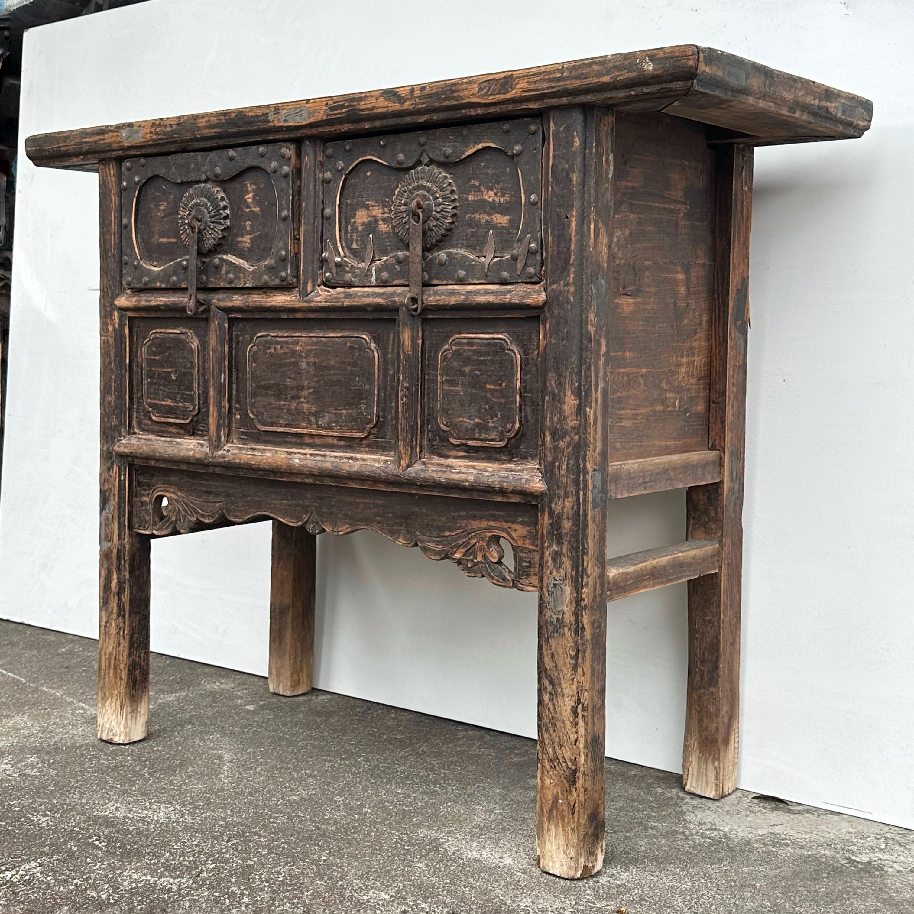 This antique coffer table from Shanxi has exceptional patina, harmonious proportions and pleasing overall aesthetics. On the drawers are cast iron handles with beautifully carved chrysanthemum flower backings, and iron studs framing the perimeter.