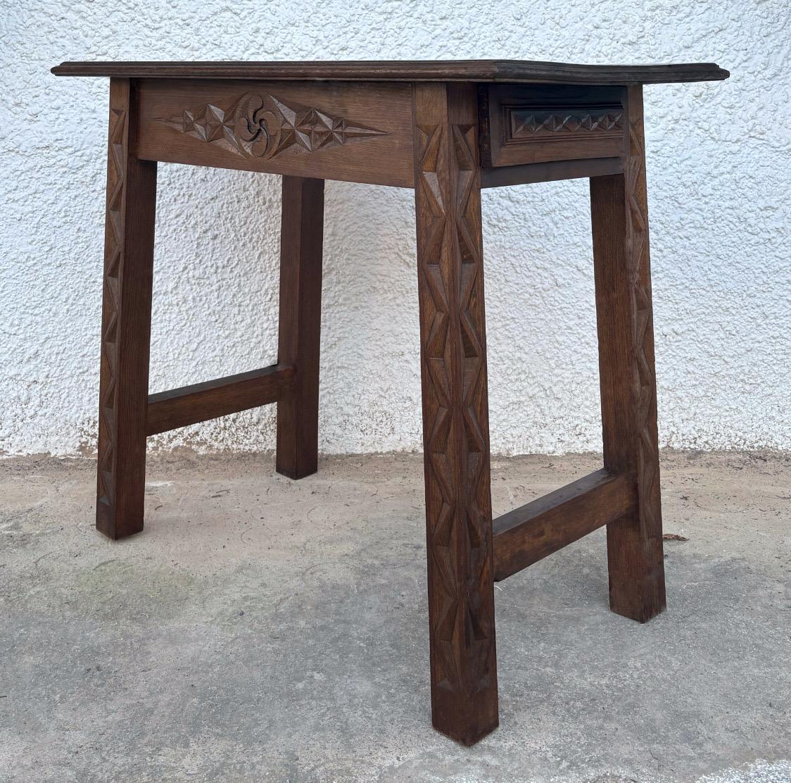 Cette table d'appoint ou table basse présente les caractéristiques d'un style rustique d'origine européenne, avec des influences qui pourraient renvoyer à des régions ayant une forte tradition de sculpture sur bois, comme les Alpes ou même certaines