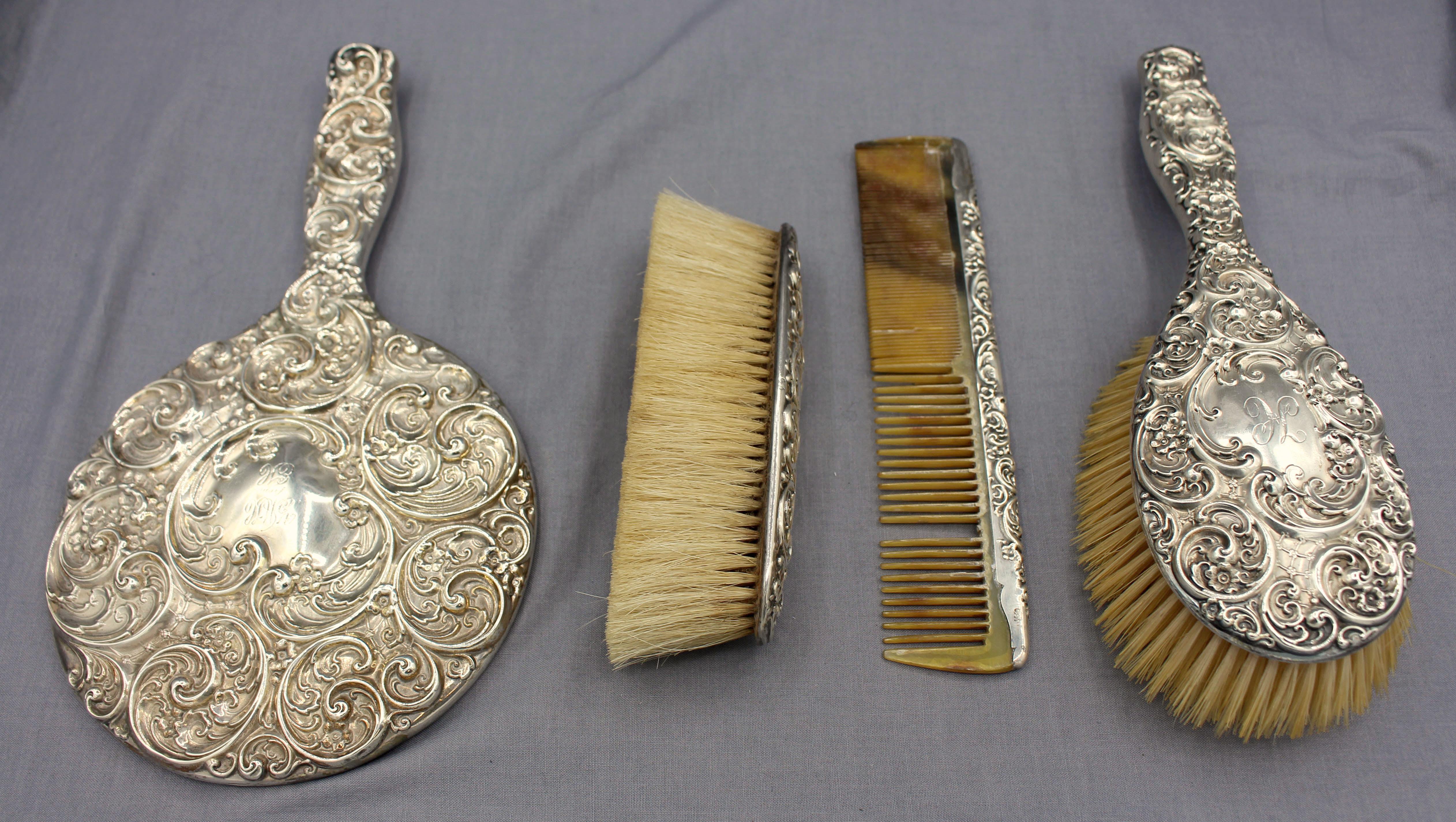 A fine late 19th century repousse decorated American sterling silver 4-piece dresser set.
Brush: 9