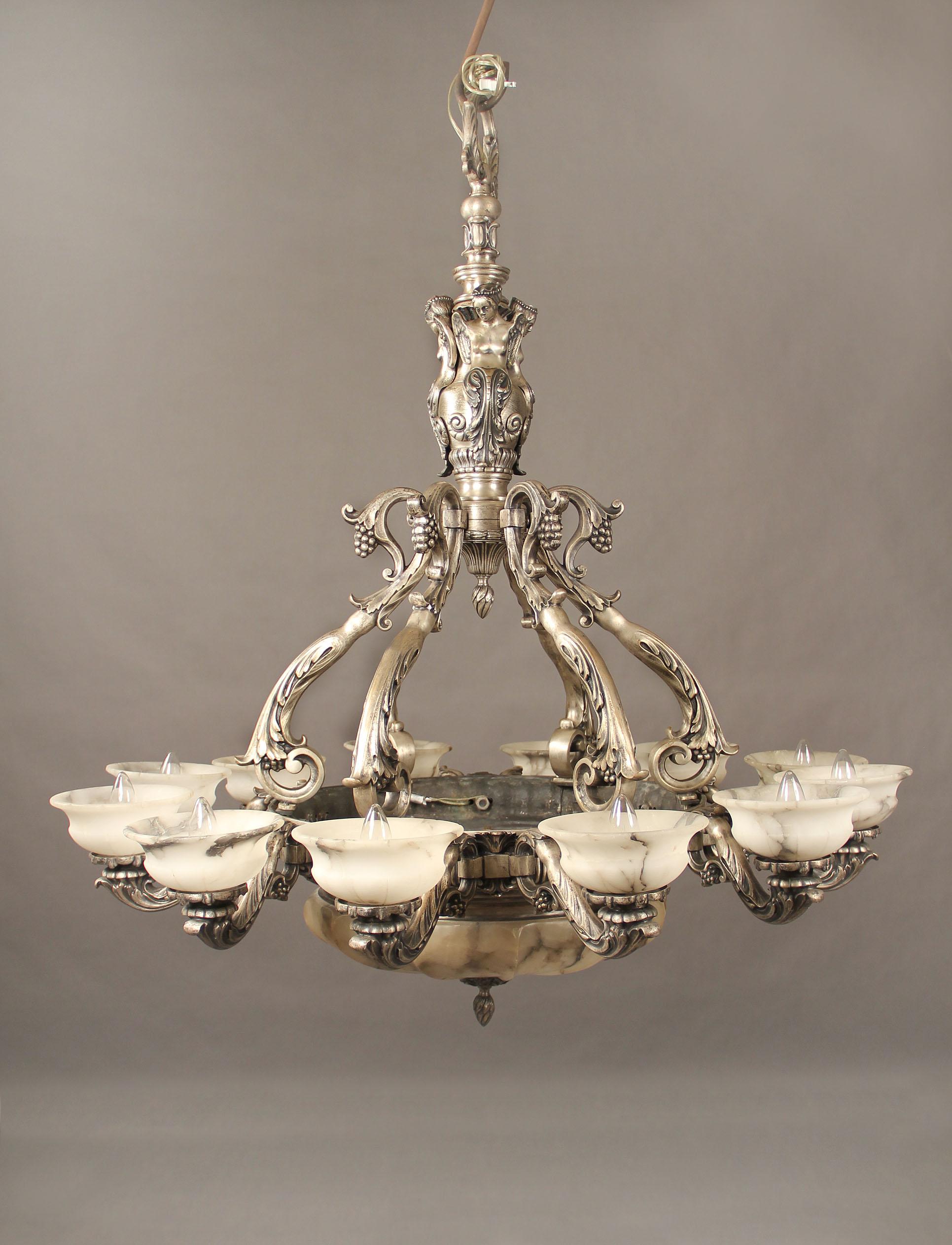 Intéressant lustre à seize lumières en bronze argenté et albâtre de la fin du XIXe siècle.

Le cadre finement moulé avec des anges, chacun des bras avec des lumières couvertes d'ombres d'albâtre, au-dessus d'une grande et belle coupe d'albâtre.