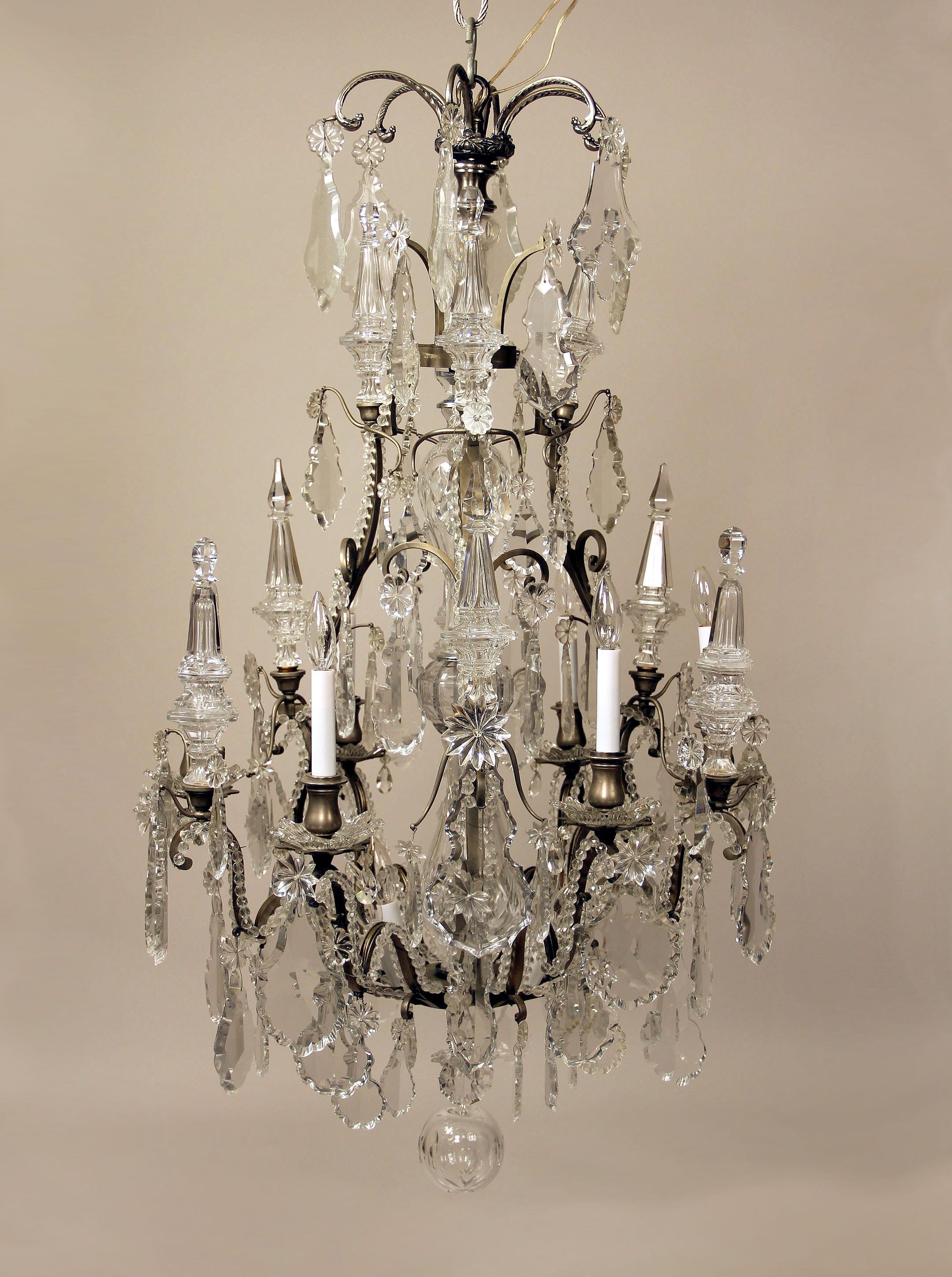  A Late 19th Century Silvered Bronze and Baccarat Crystal Twelve Light Chandelier

Multi-faceted and shaped crystal, beaded arms, cut crystal central column, 9 tiered spears with six interior and six perimeter lights, bobeche cups.
