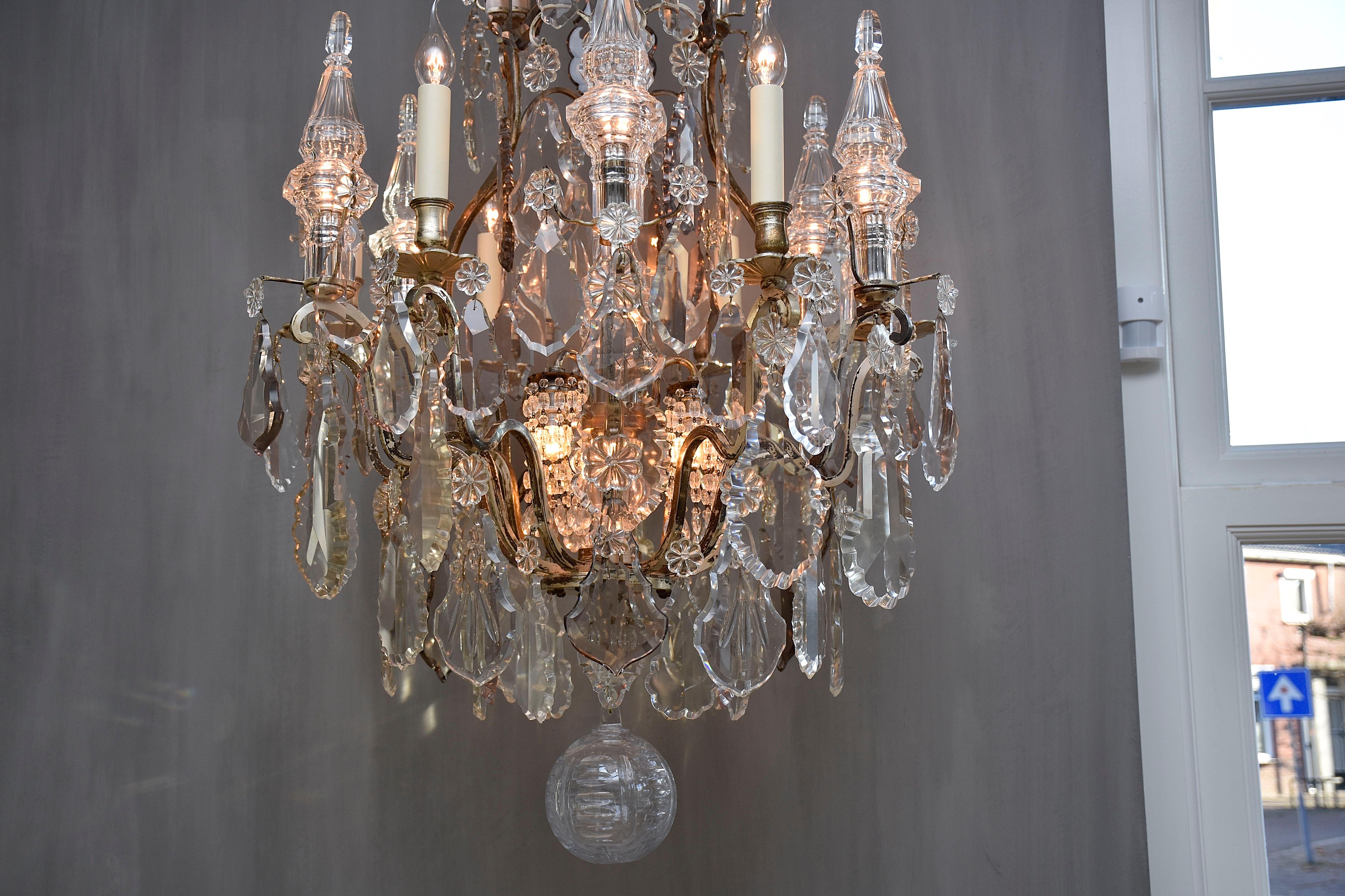 Un lampadario francese molto elegante in stile Luigi XV.
Con 6 luci intorno al lampadario e 10 luci piccole.
Forma di gabbia. Cornice in bronzo argentato con qualche segno di usura (vedi foto)
Il lampadario è riccamente decorato con bellissimi e