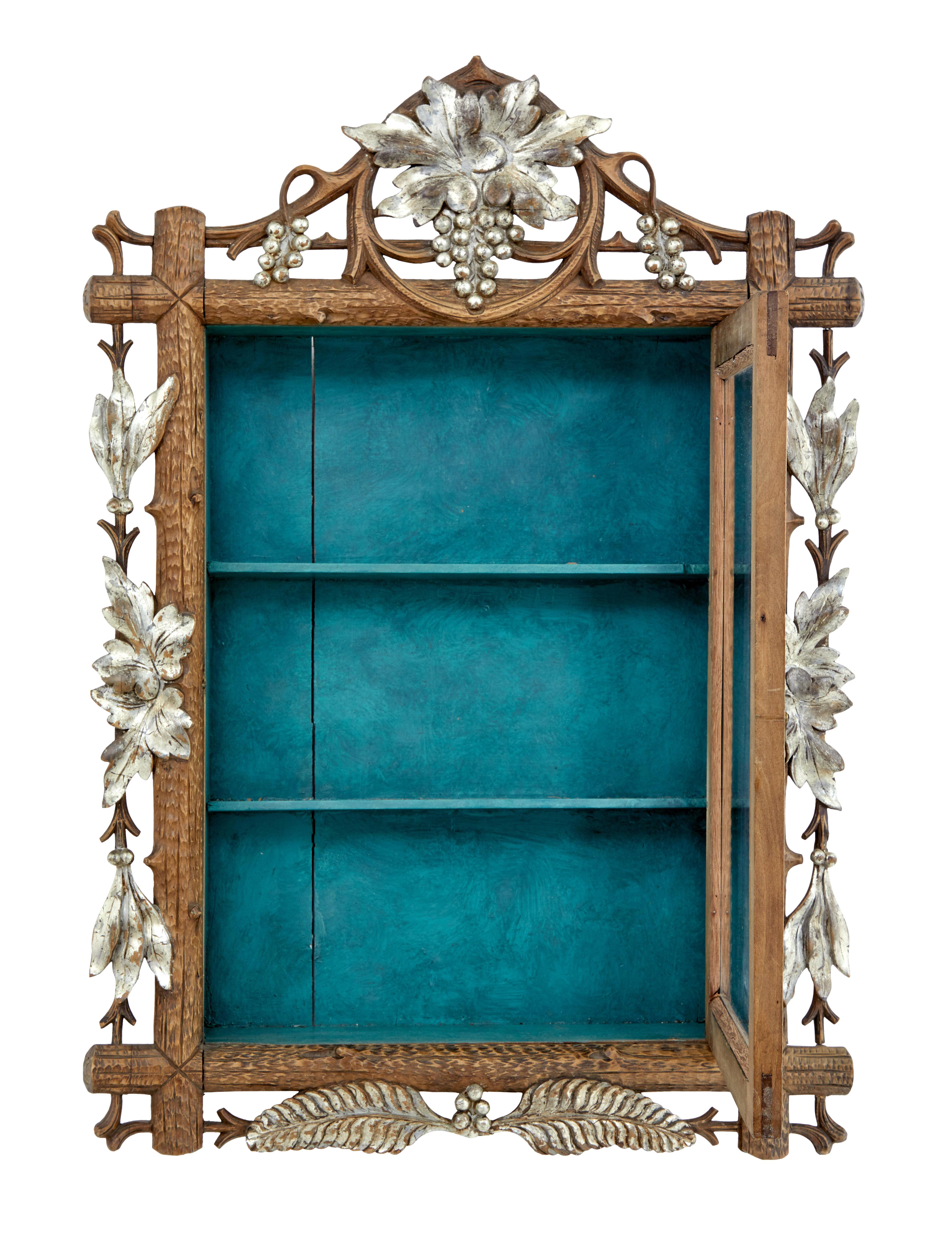 Late 19th century small Black Forest display cabinet, circa 1890.

Good quality small display hanging display cabinet made from linden wood, with silver gilt elements. Single glazed door which opens to a painted interior containing 2 narrow