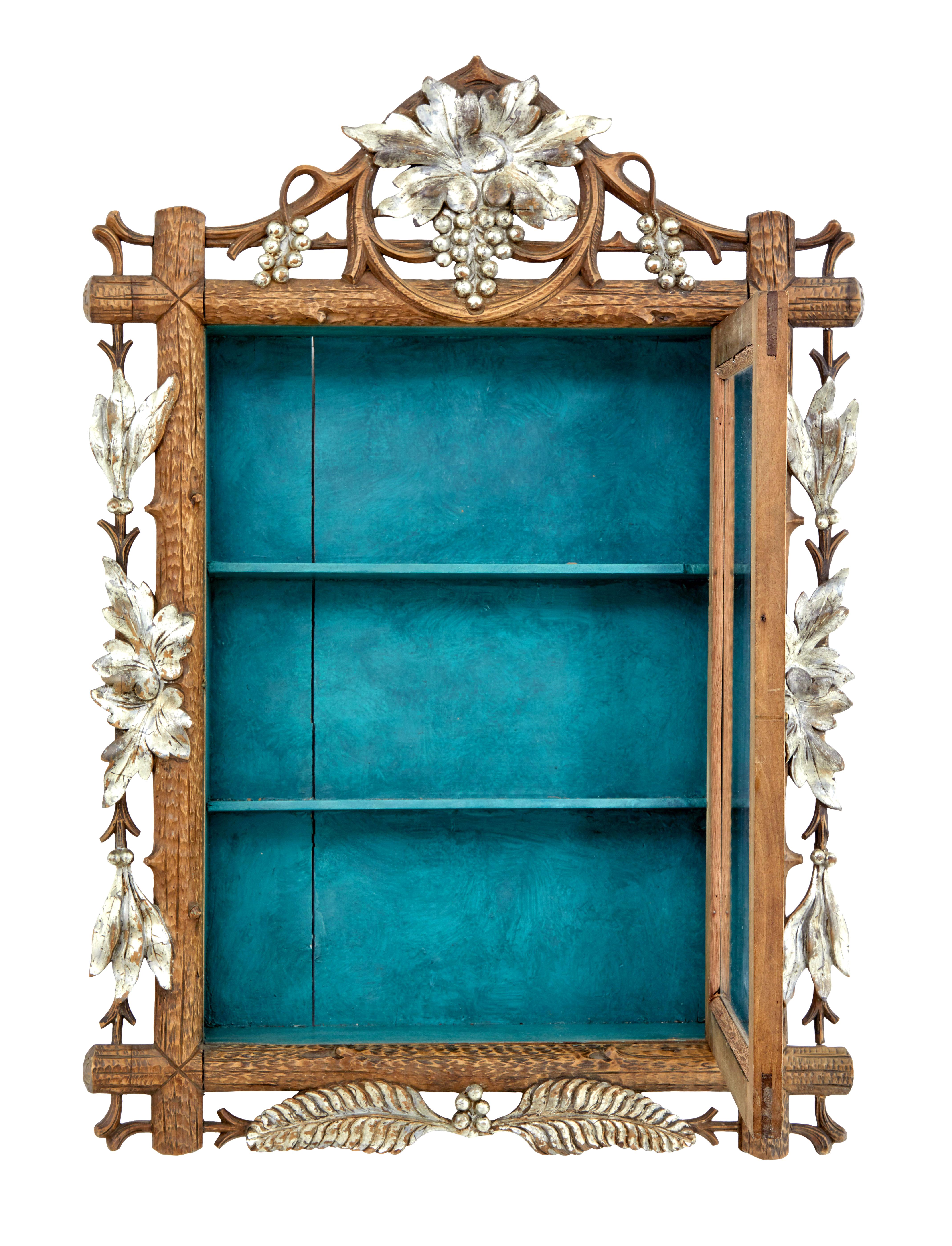 Late 19th century small Black Forest display cabinet circa 1890.

Good quality small display hanging display cabinet made from lindenwood, with silver gilt elements. Single glazed door which opens to a painted interior containing 2 narrow shelves.
