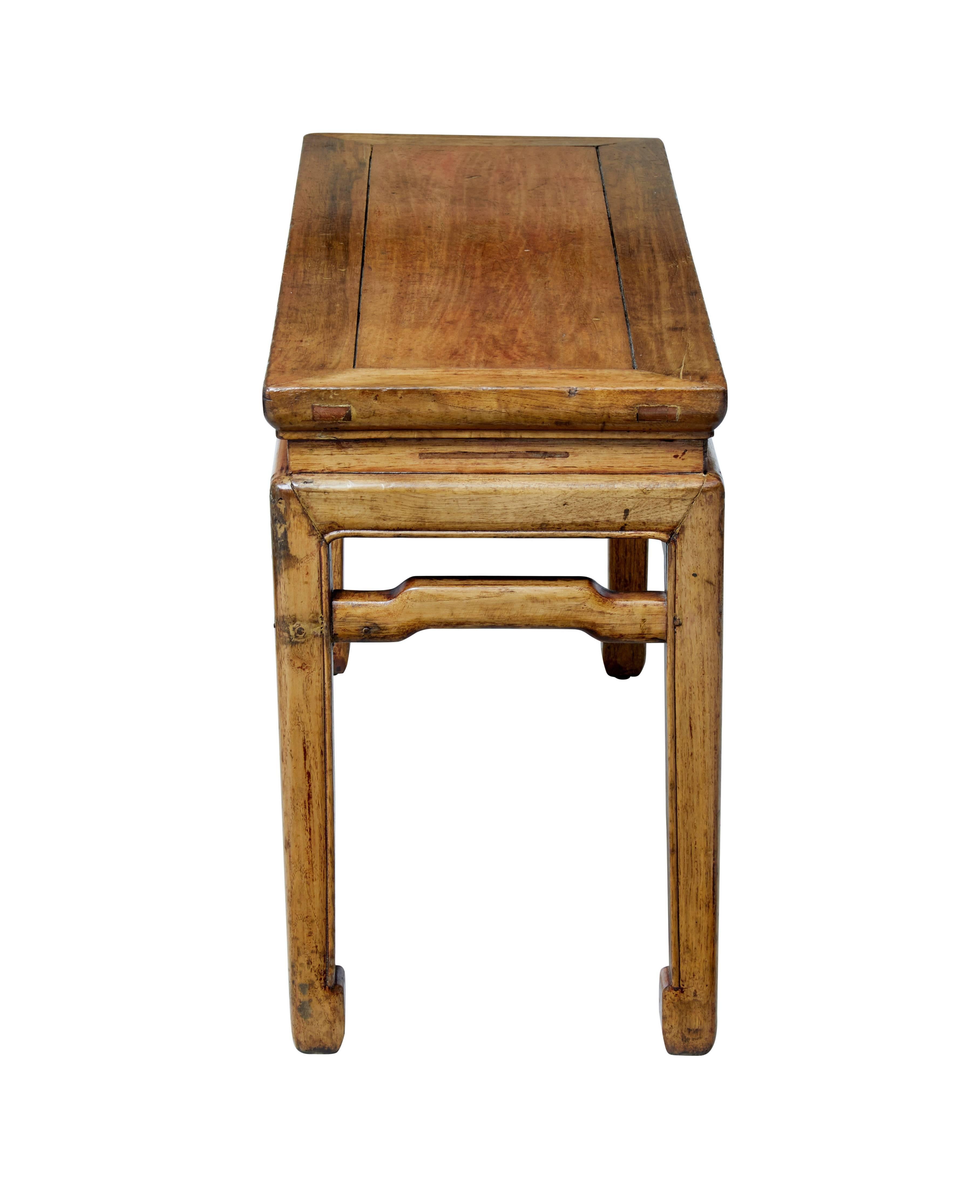 Practical piece of late 19th century Chinese export furniture.

Hard wood similar to elm presented in a lacquered finish.

Flat seat on square legs united by shaped stretcher. Ideal for use in a hallway or cloak room.