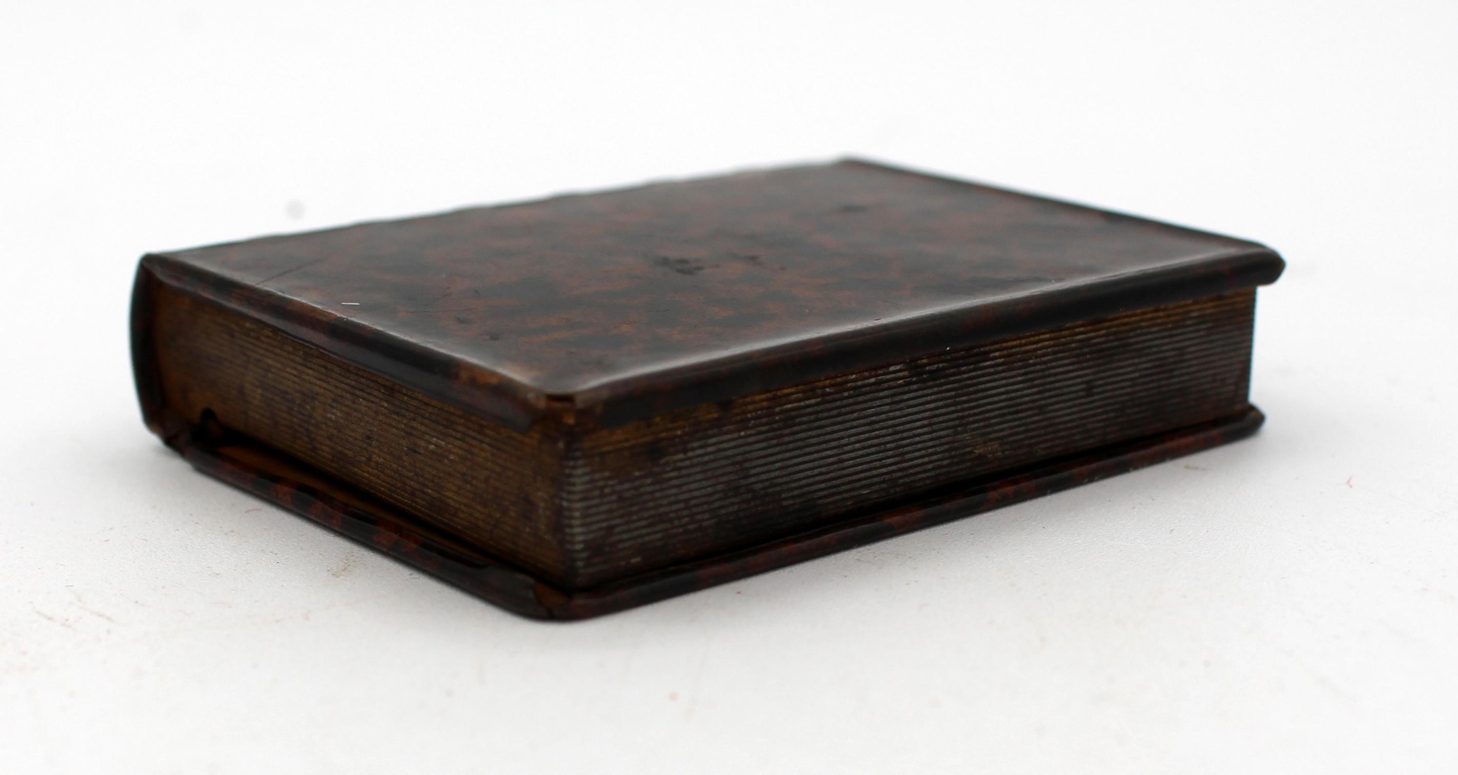 Small faux book box of well painted tole to look like the leather with the tooling work of a fine book with gilt page edges. English, late 19th century.
Measures: 3 1/4
