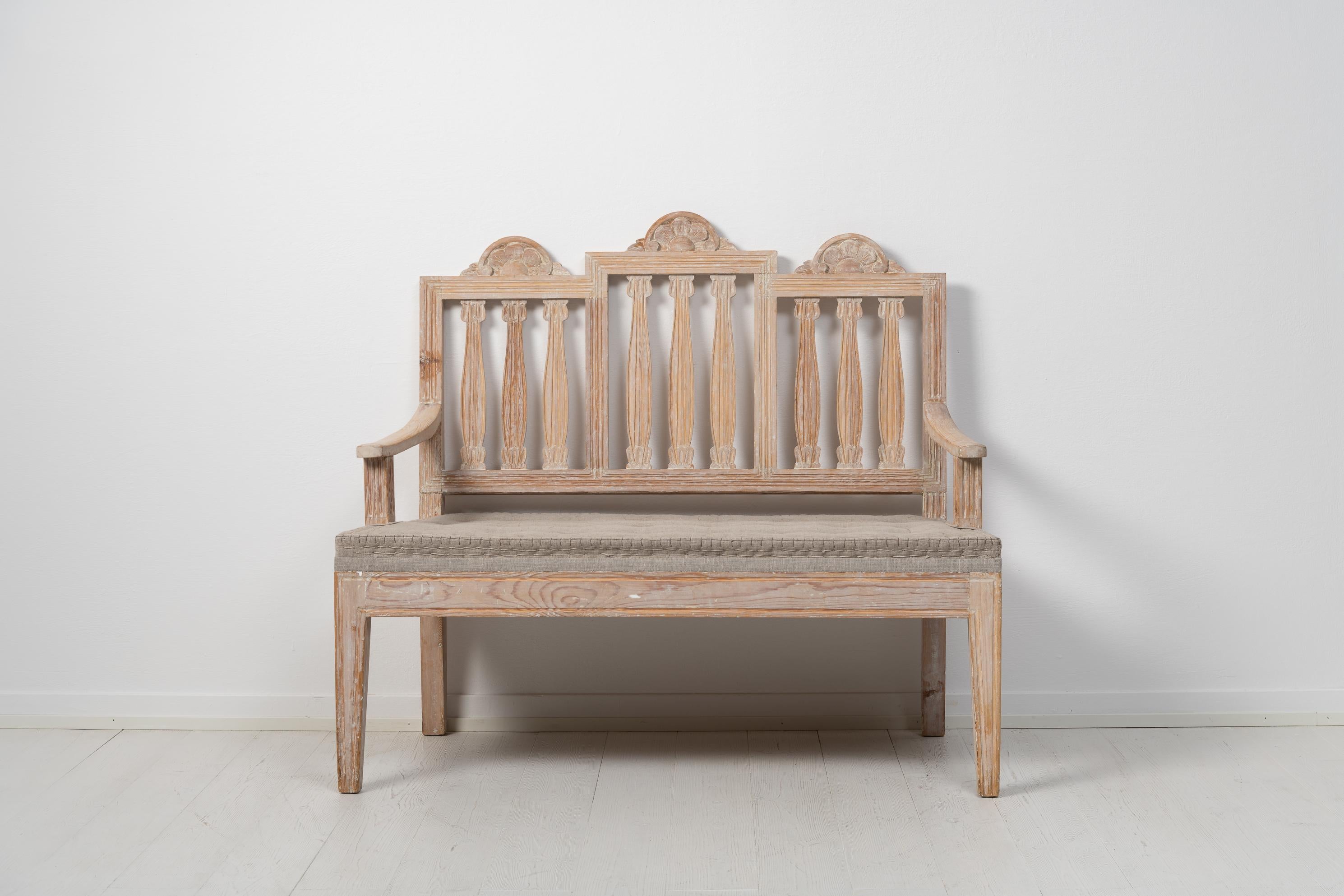 Swedish small sofa in gustavian style. The back of the sofa consist of 3 sections with the typical gustavian decor and shape. The sofa is from the late 1800s and made in pine. Hand carved wooden decor and straight legs with flutes. The sofa has