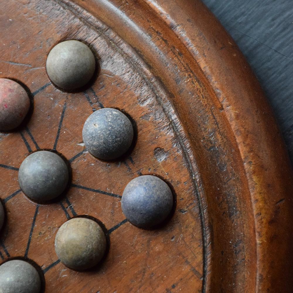 Late 19th century Solitaire Board Game

We are proud to offer a solid mahogany Victorian solitaire board with 33 stone marbles, also ideal for playing the game of fox and geese and the military game of German tactics. The board stands on three