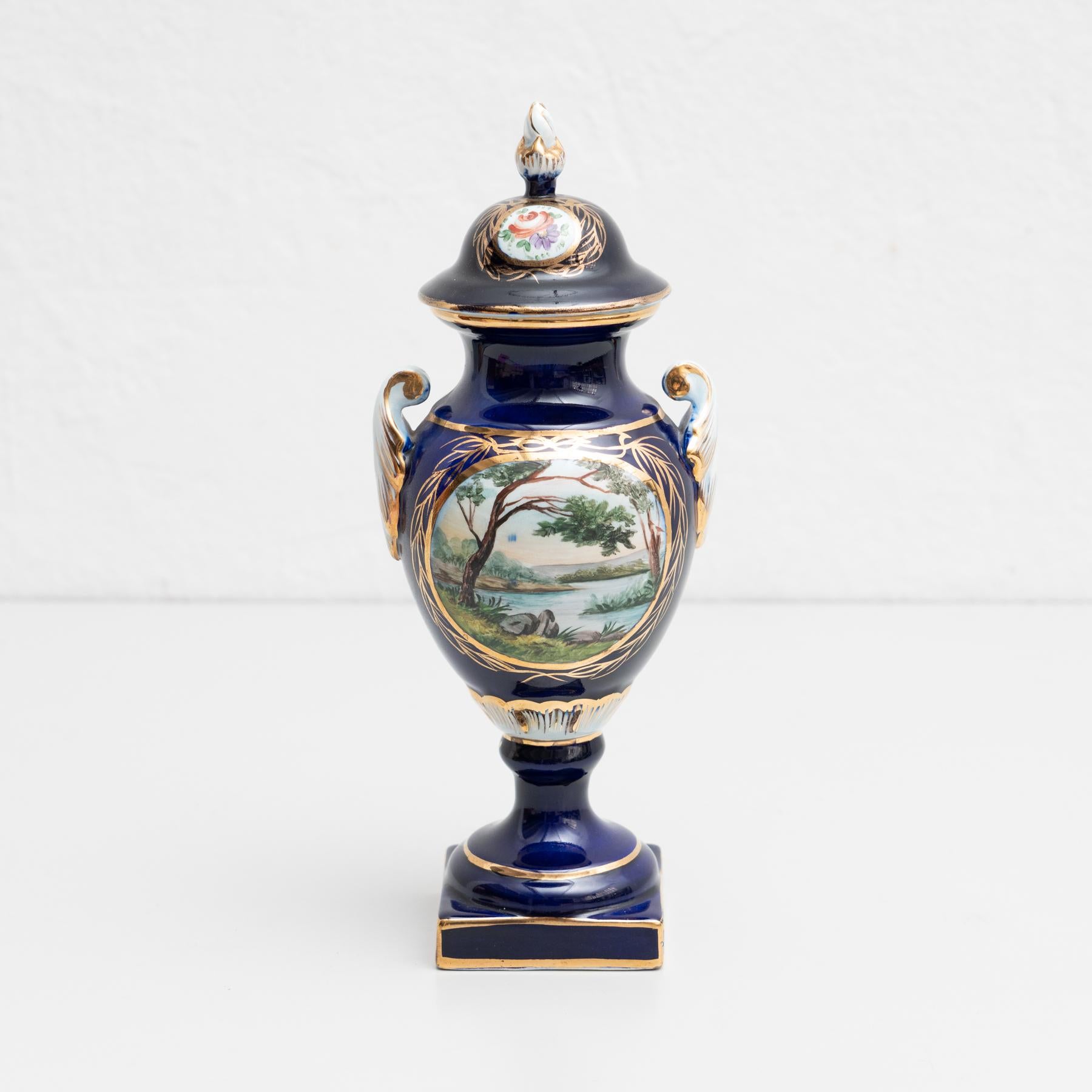 Isabelline hand-painted porcelain vase in the Serves style. Beautifully decorated with a nice scene on the front side. The vase features a lid that can be lifted off.

Made by unknown manufacturer in France, circa 19th Century.

In original