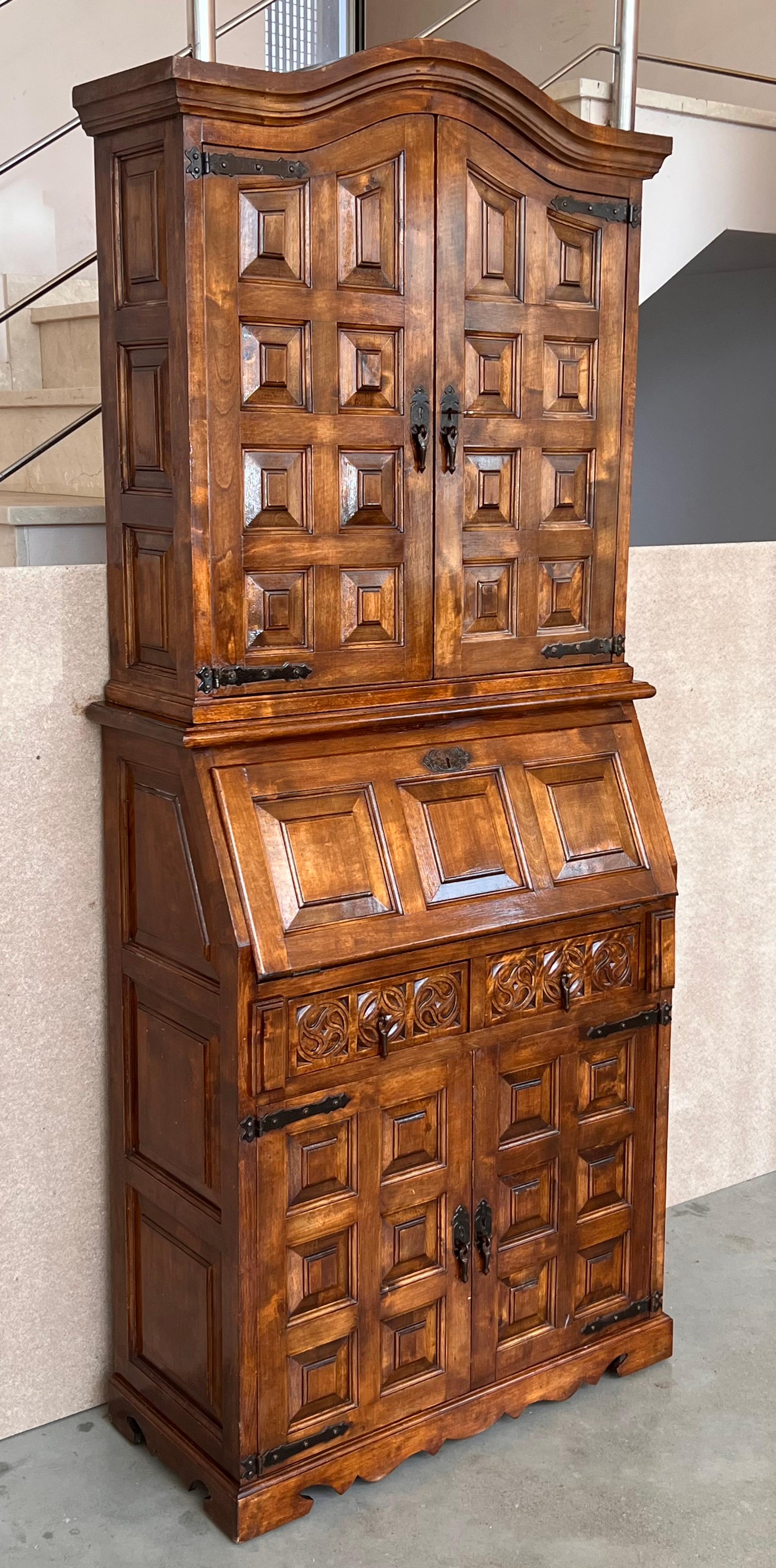 A late 19th century Spanish Walnut Bureau bookcase ‘secretaire’ with fretwork open swan neck pediment, centred by a shaped finial, above a pair of doors, slant front enclosed writing surface, fitted drawers and cubbies and below two graduated wide