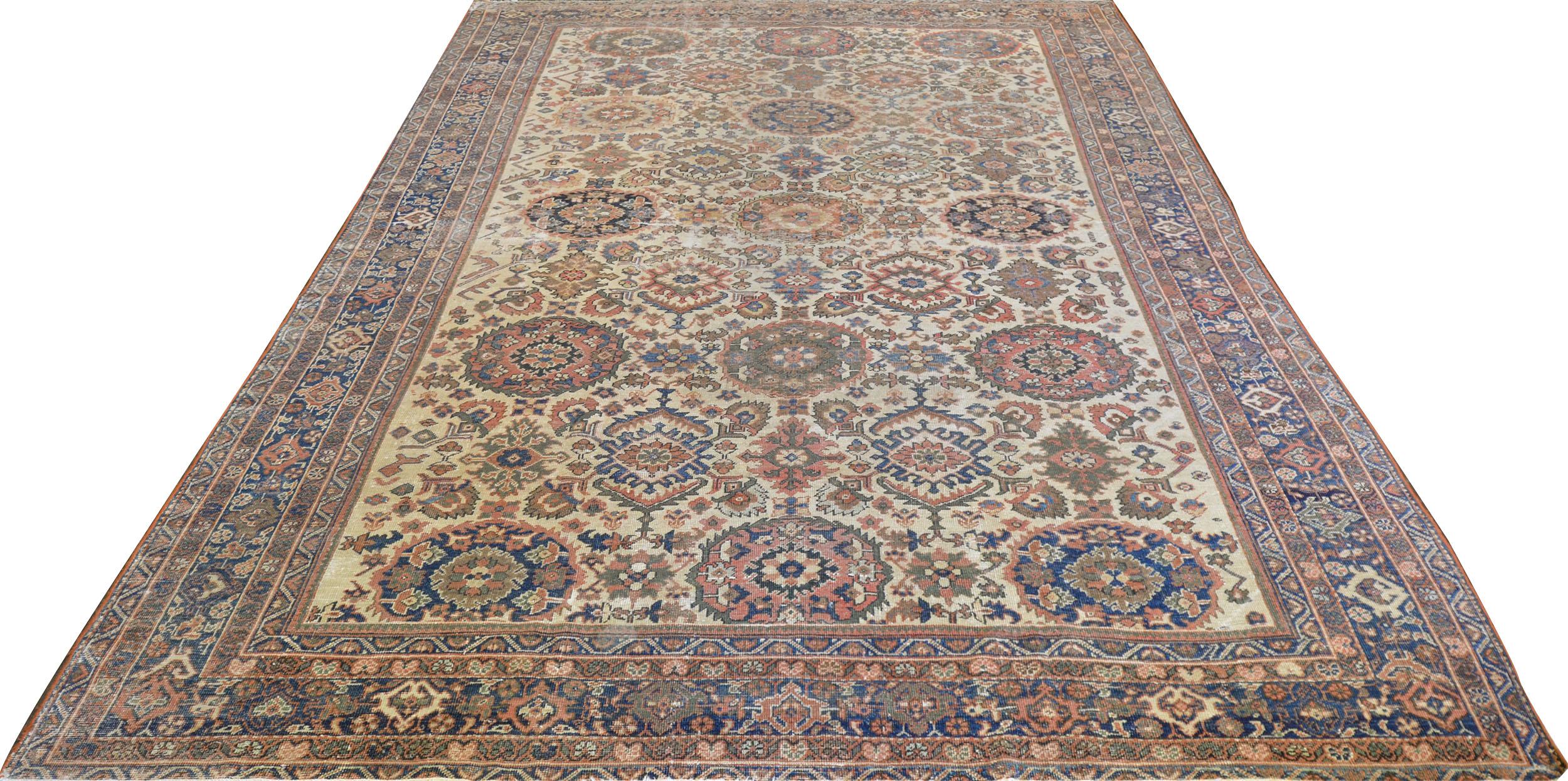 This traditional handwoven Persian Sultanabad rug has a warm cream field of regal palmette pendants checkered with further floral lozenges, and geometric motif, in a refined indigo palmette border, between a profusion of ornate floral vine and