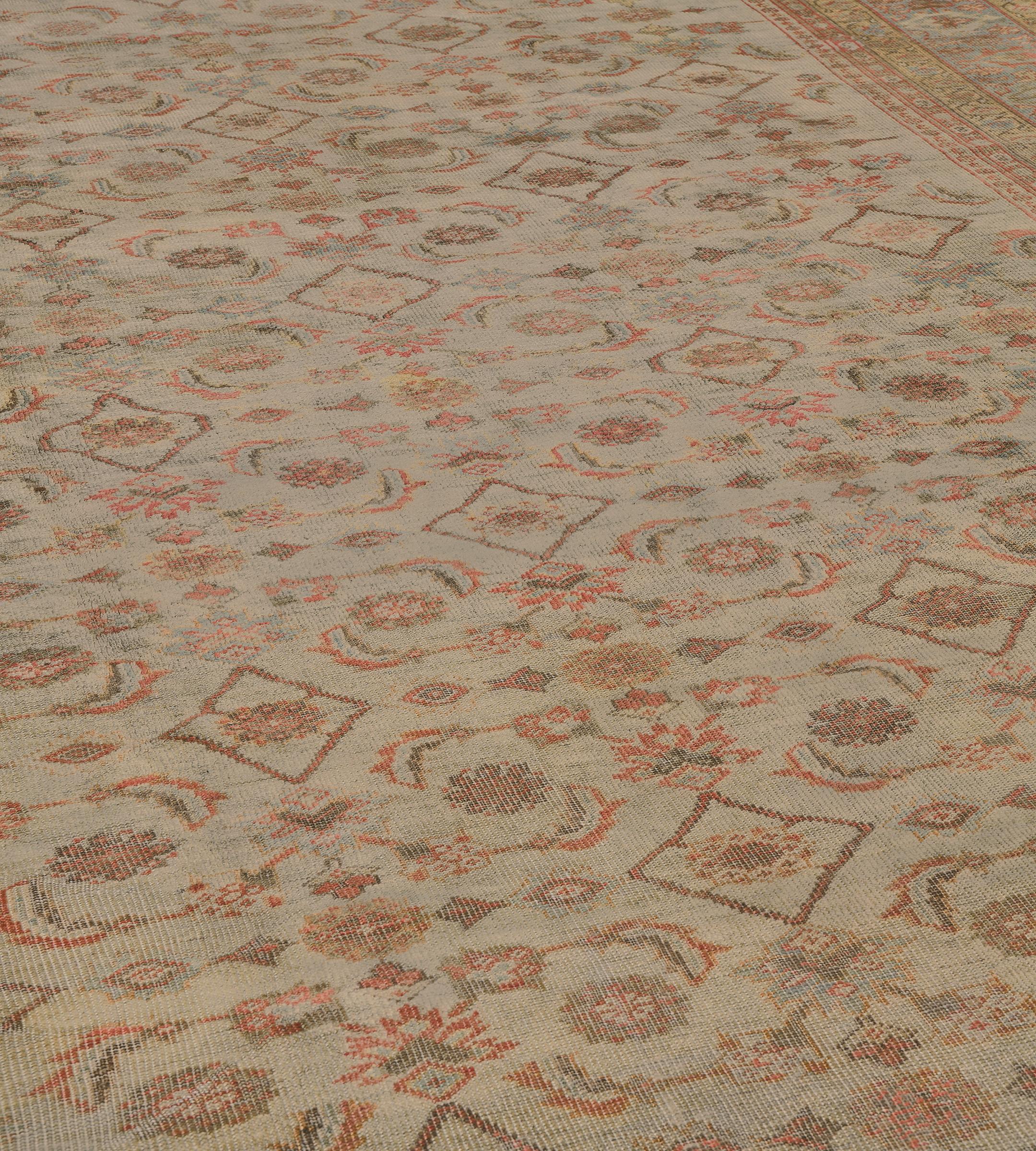 Questo tradizionale tappeto persiano Sultanabad Rugs, tessuto a mano, ha un campo color avorio sabbioso con un motivo herati stilizzato, in un bordo avorio sfumato di palmette che emettono un motivo mil-fleur, tra una profusione di strisce floreali