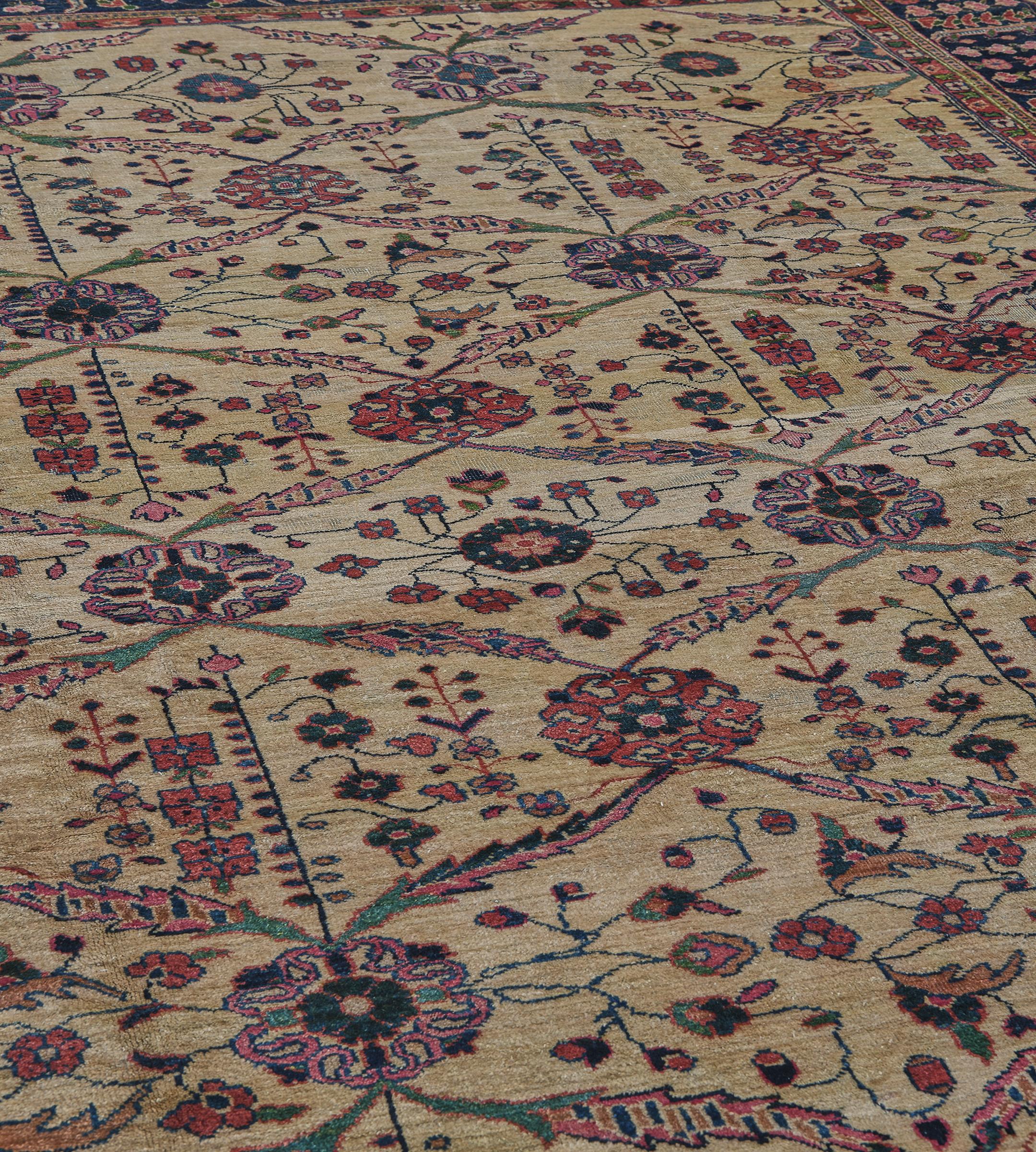 Questo tradizionale tappeto persiano Sultanabad Rugs, tessuto a mano, presenta un campo complessivo color sabbia con file alternate di teste di fiori stilizzate che emettono un reticolo di fronde a losanga, ognuna delle quali racchiude serpeggianti
